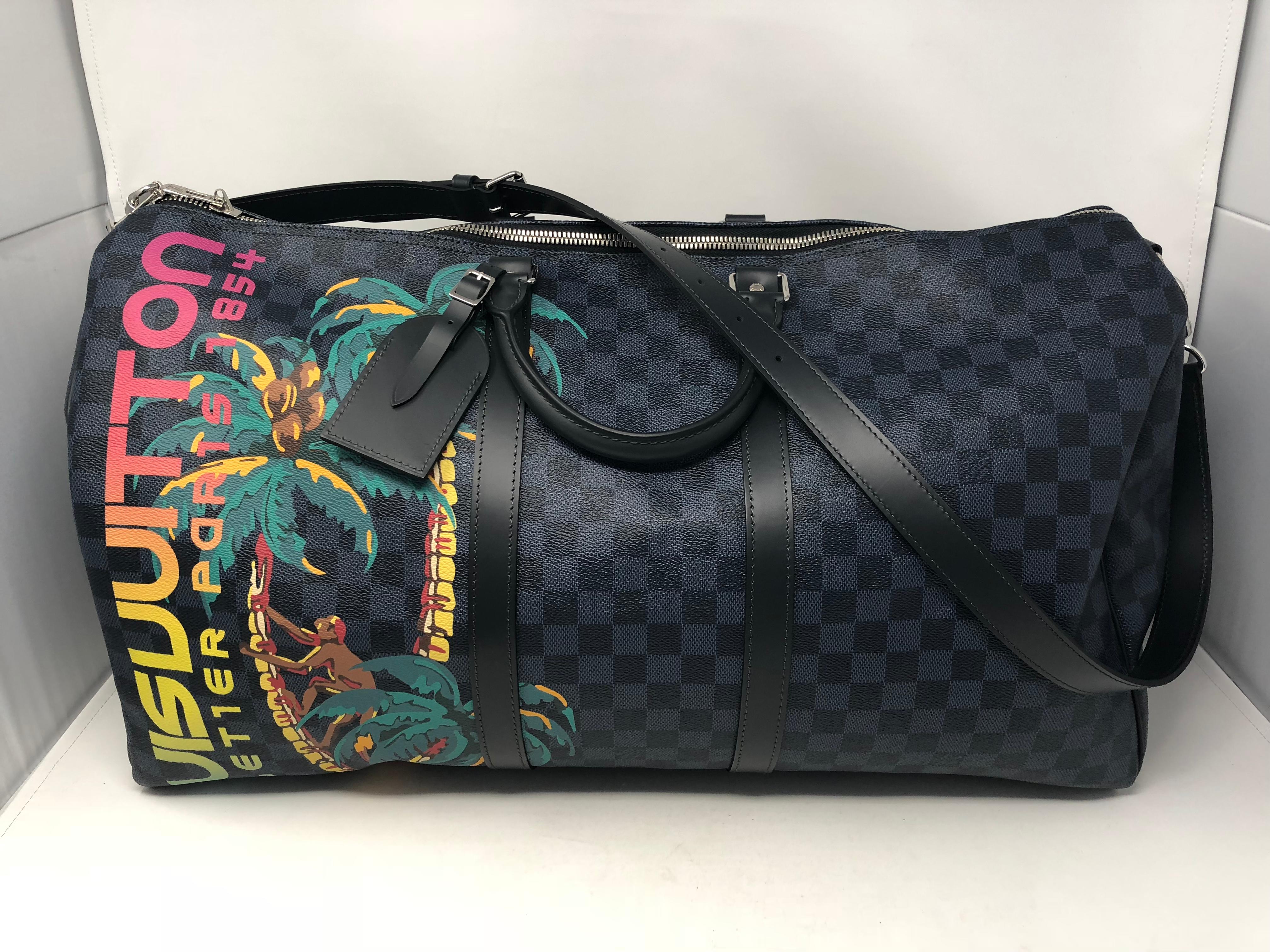 Louis Vuitton Bandouliere 55 in Damier Cobalt Canvas. From the 2018 Spring/ Summer Men's Fashion Show and one of Kim Jones last designs. The Jungle theme shows a playful monkey on a palm tree with LV in rainbow signature. Leave it to LV for artistry