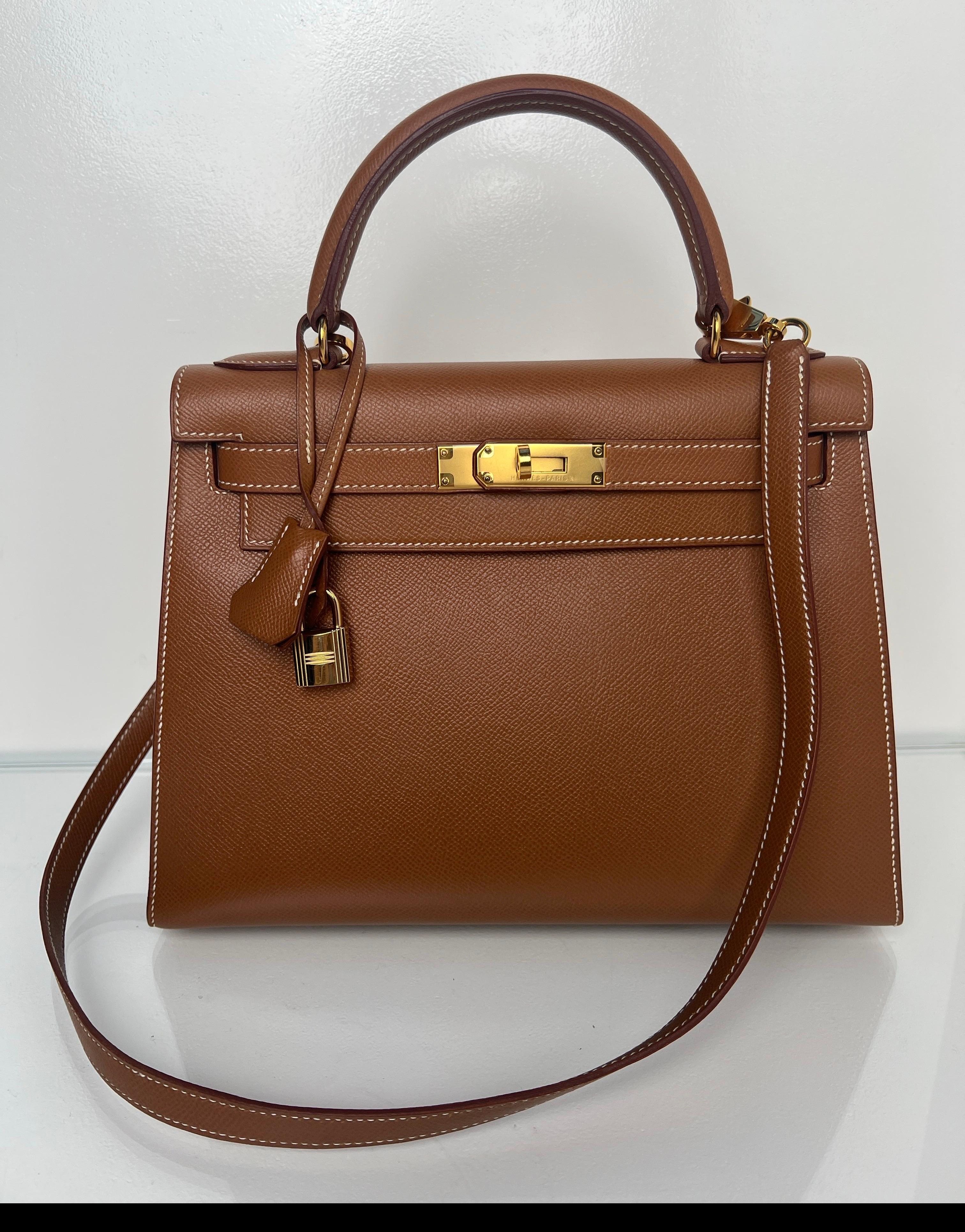Sac Hermes Kelly Sellier 28 en or. Couleur dorée avec quincaillerie dorée. La taille 28 la plus demandée en Kelly. Intérieur propre. Excellent état. Sellier est plus structuré et celui-ci est magnifique. Comprend une clochette, un cadenas, des clés