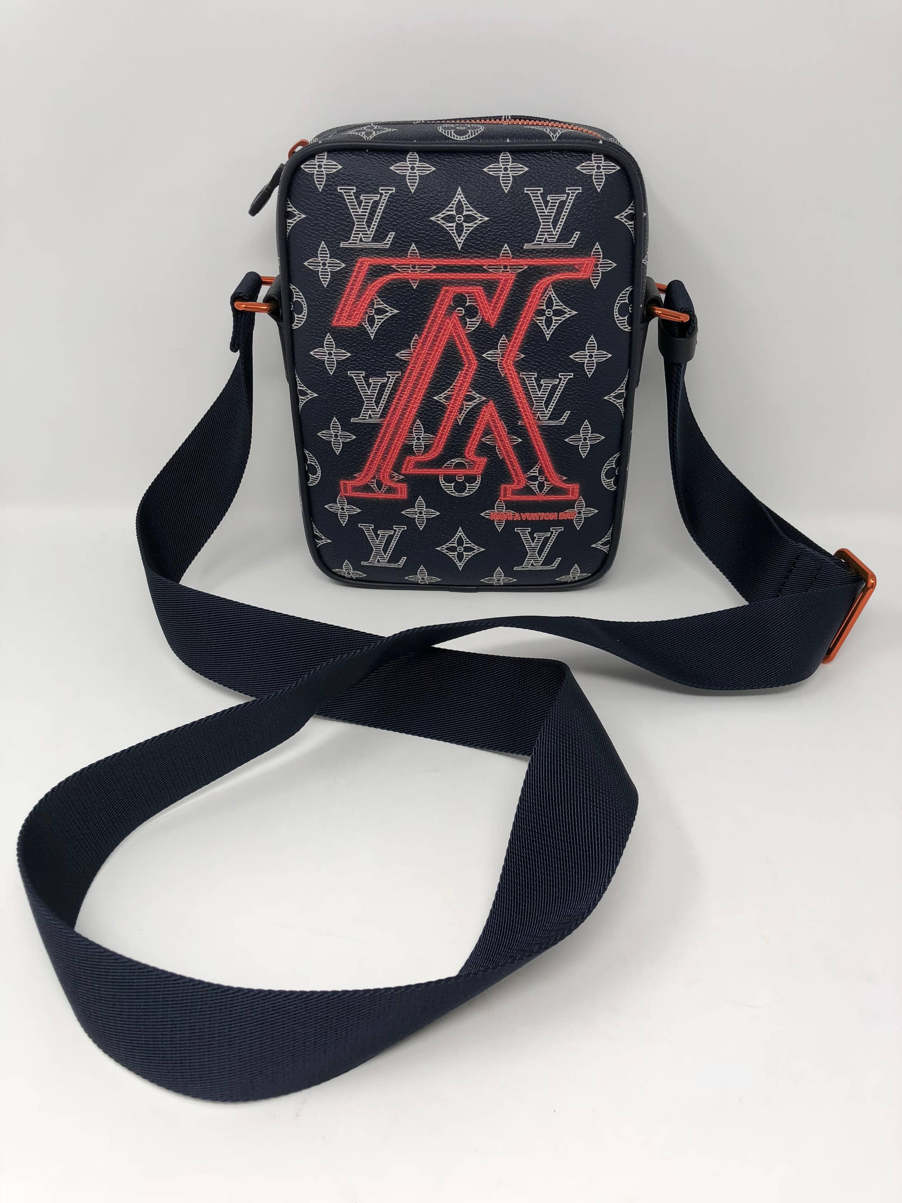 Louis Vuitton Crossbody called the Danube City Monogram Upside Down Ink is brand new with box and dust cover. The adjustable strap makes it short enough for over the shoulder or across the body. The navy monogram called ink is highlighted with coral