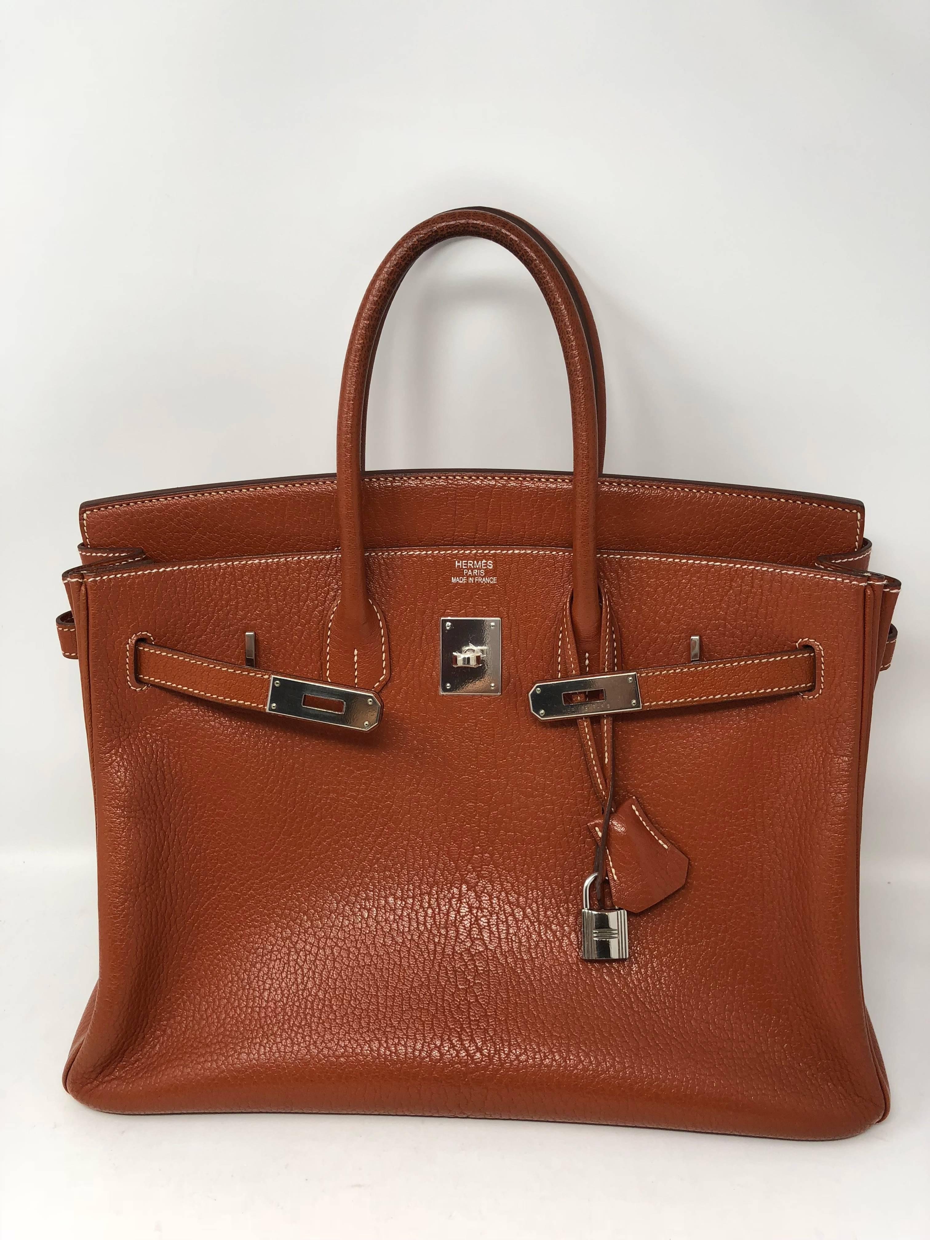 Hermes Potiron Orange Leather Birkin 35 with palladium hardware. Potiron Orange is a muted shade of orange with brown undertones. This Birkin is from 2006 and good condition. Handles do have normal wear for age of bag. Please note the darkening
