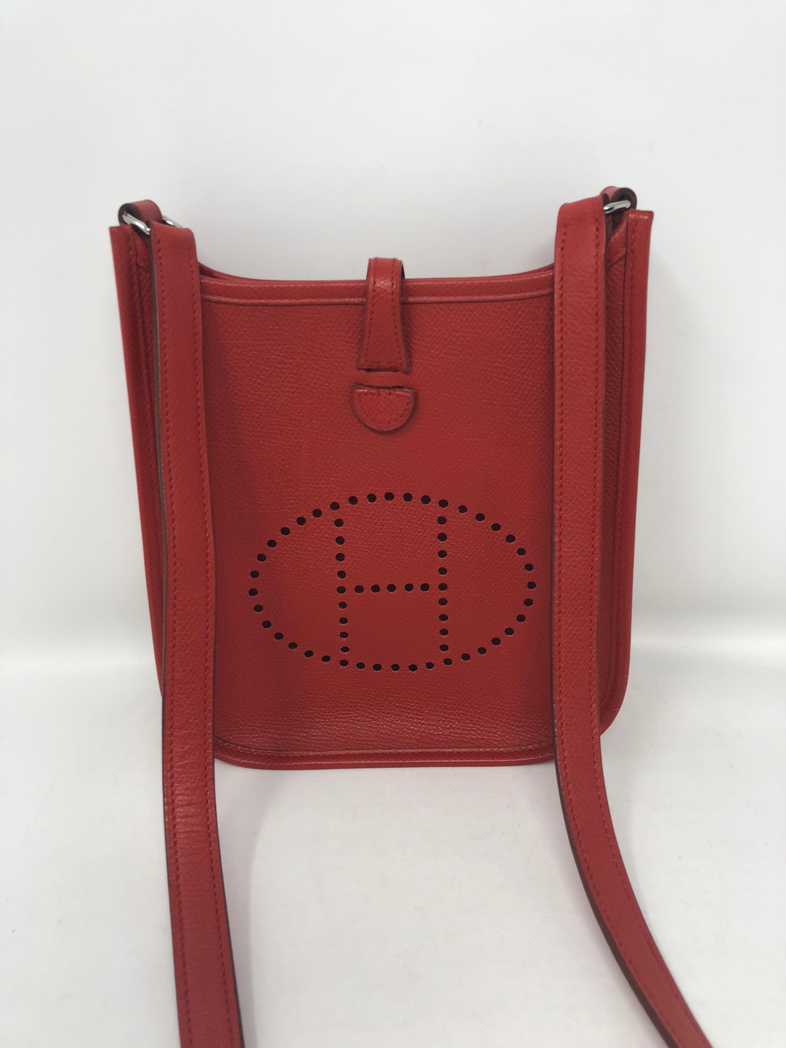 Red Hermes Evelyne TPM Mini crossbody bag in Epsom leather which is scratch resistant.  Palladium hardware. Mini size is hard to find and rouge casaque color. Signature perforated H on front of bag. Guaranteed authentic. 