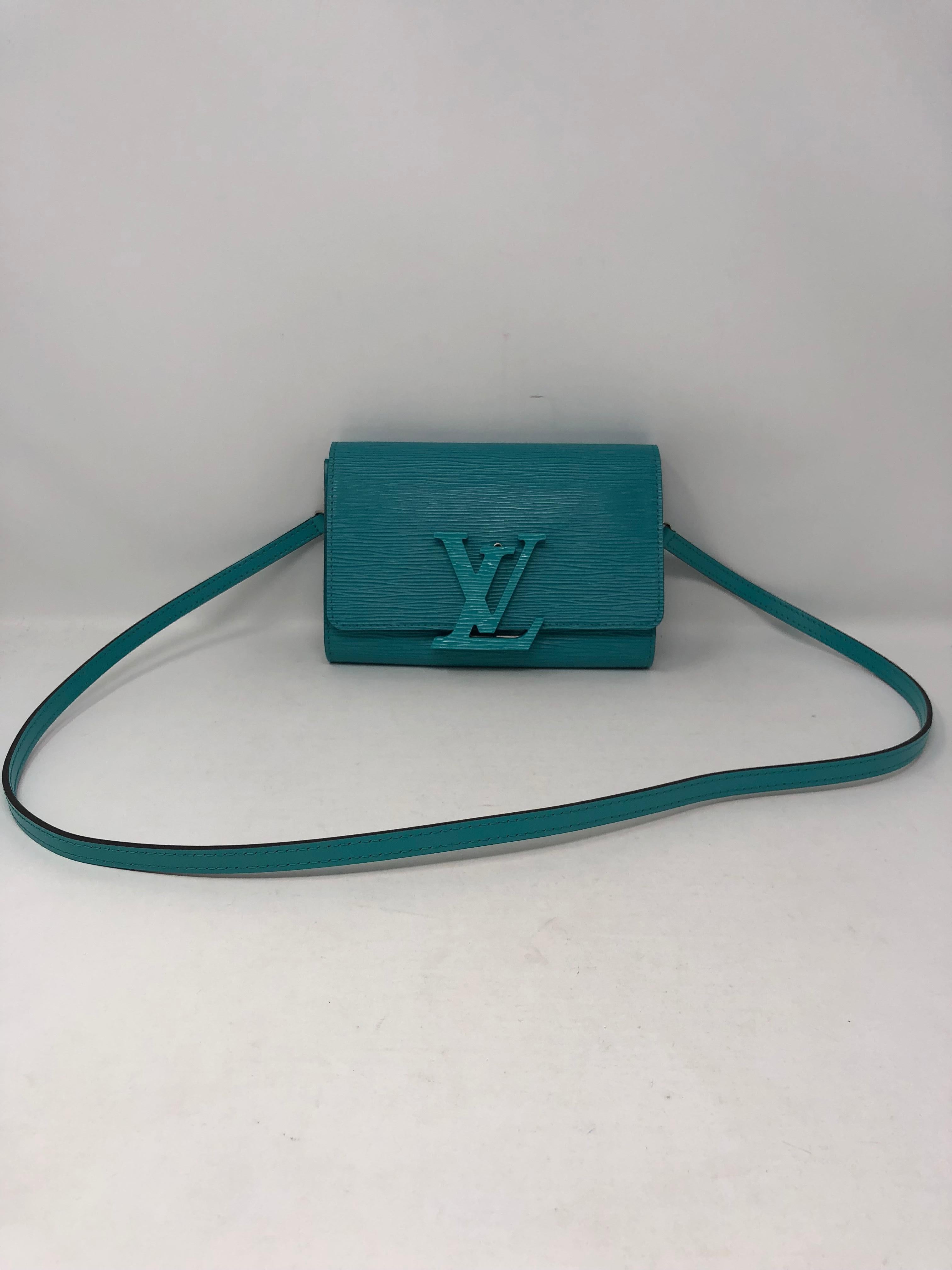 Louis Vuitton Pochette Louise in Turquoise Epi leather color. The bag can be worn as a clutch or shoulder bag. Comes with matching detachable strap. Mint condition and rare color. Flip lock featuring the tonal 'LV' logo and all leather bag. Silver