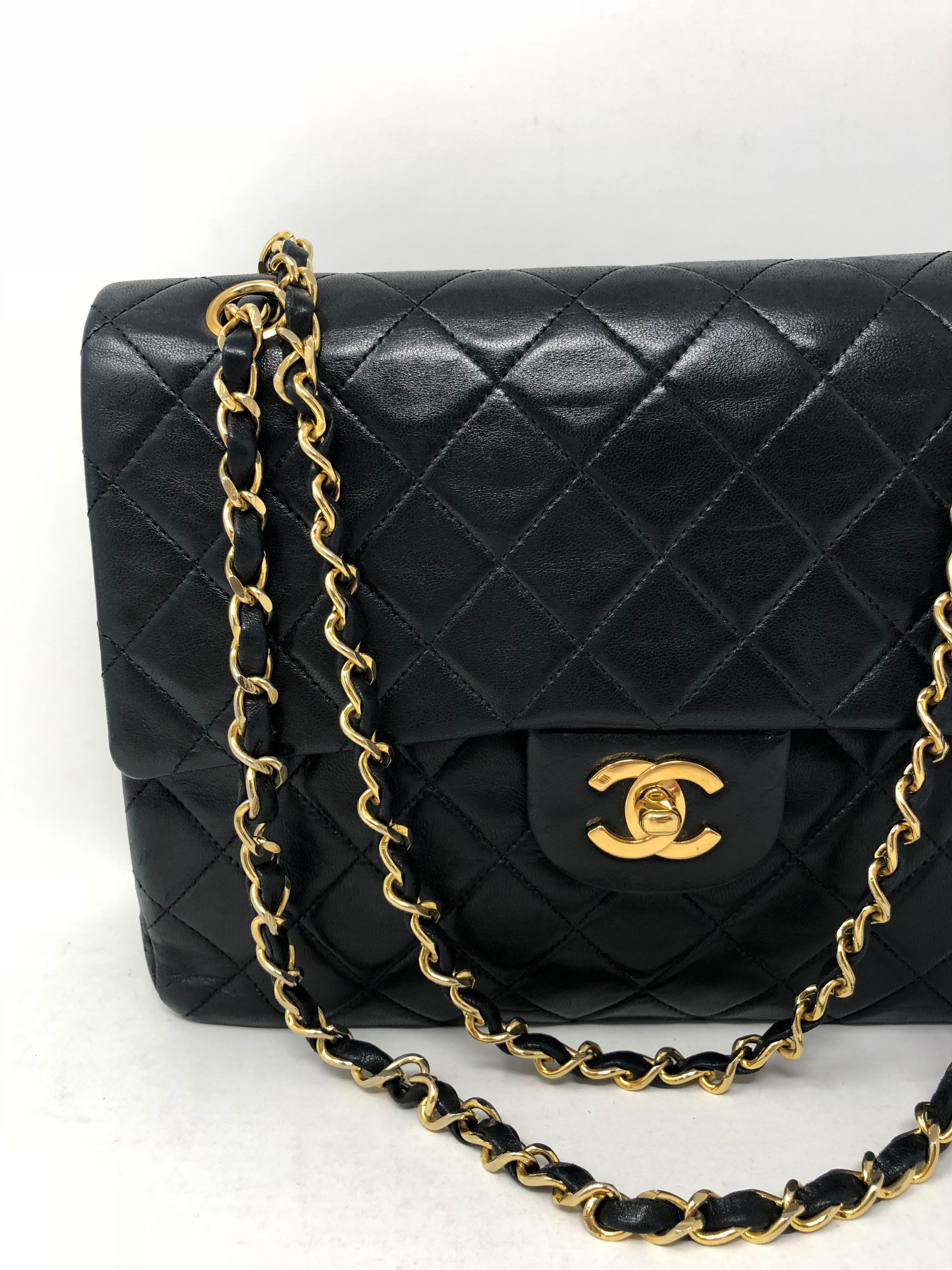 Chanel vintage square classic double flap bag in quilted lambskin leather. Beautiful black color with woven-in leather gold chain strap. Can be worn with straps doubled or worn with longer strap. Timeless and classic style from Chanel. Medium size