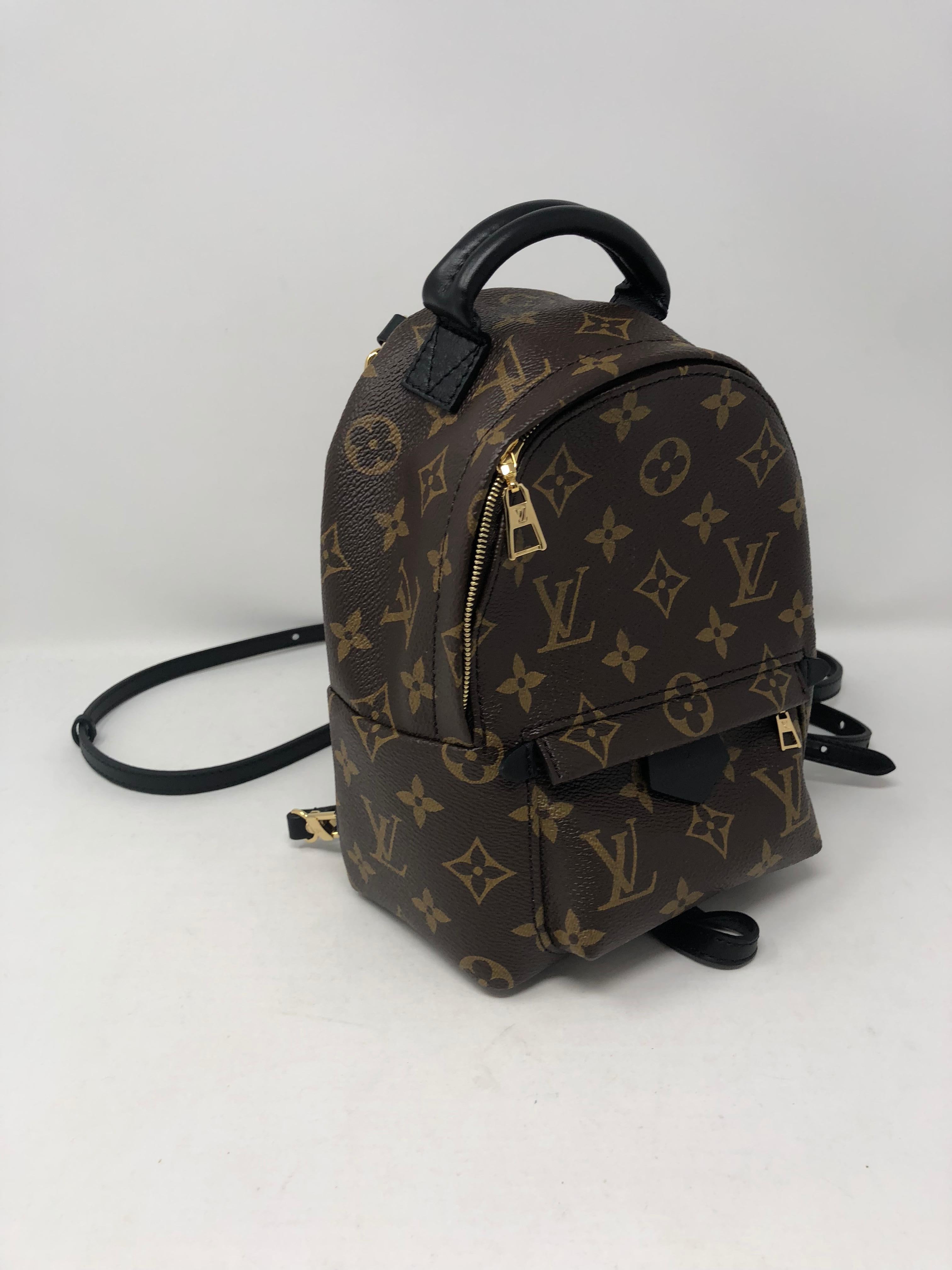 Louis Vuitton Palm Springs Mini Backpack in monogram with black leather trim. Designed by Nicholas Ghesquiere. Sold out and limited. The straps on the back can be worn as a crossbody bag , belt bag, or backpack. Even as a side cross bag. High in