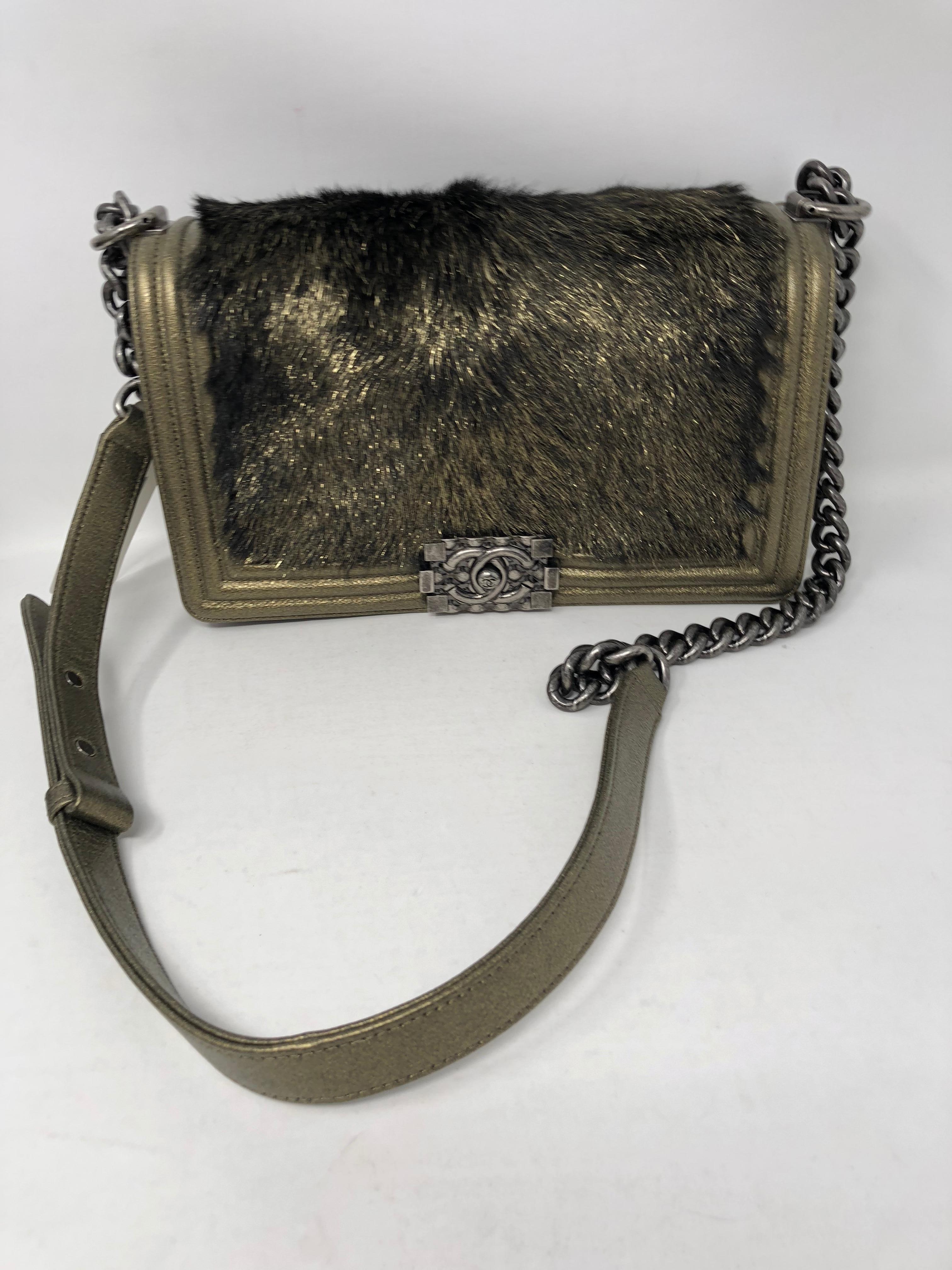 Chanel Gold and Black Fur Boy FlapBag. Metallic gold leather in medium size Boy. Original tag of $4700 still on the purse. Never used. Brand new condition. Cool fur on front next to all the metallic leather makes this a very unique bag. Can be worn