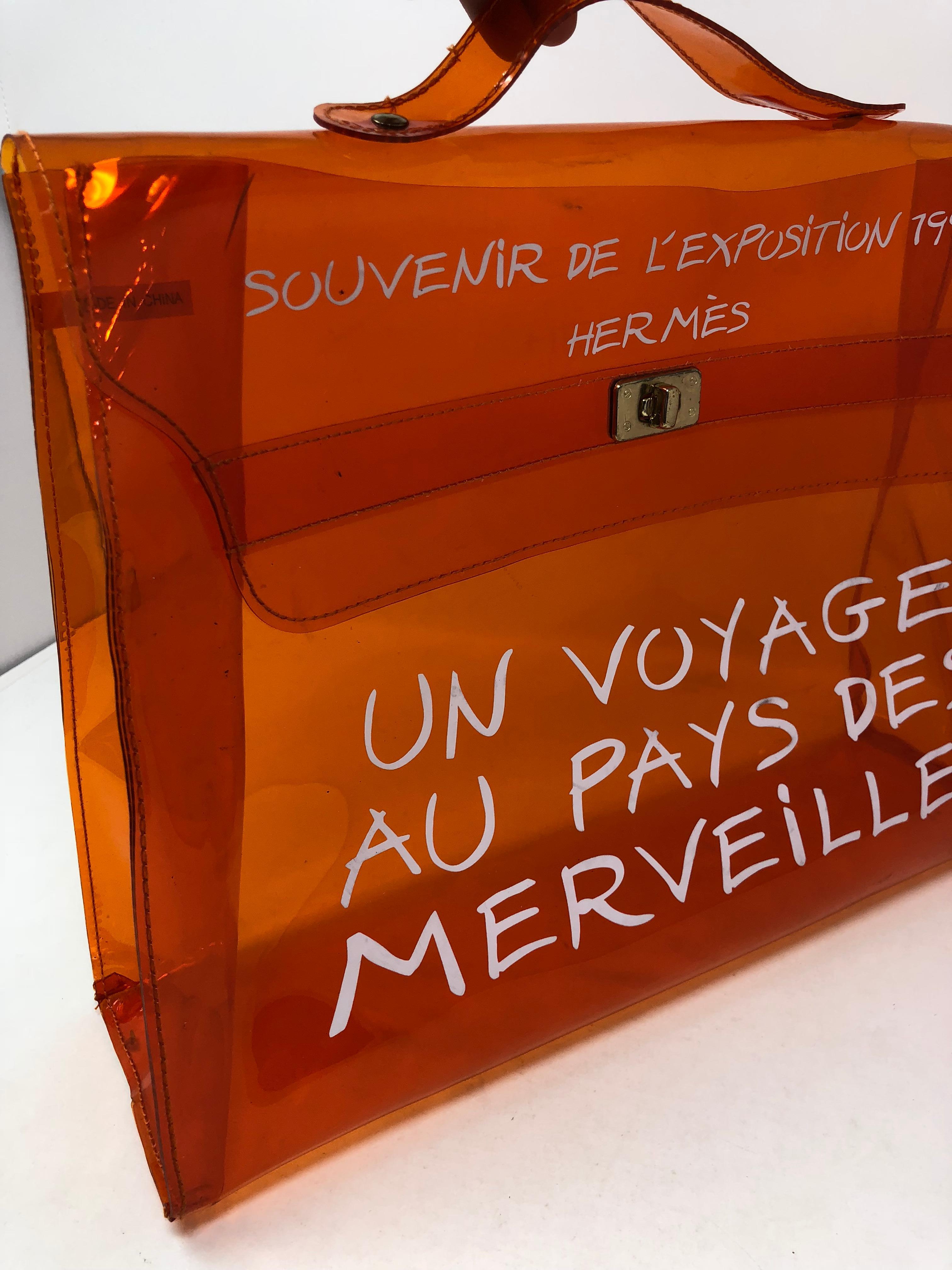 Hermes Vintage 1998 Kelly Souvenir De L'Exposition Vinyl Translucent Bag. This clear bag in orange vinyl is stadium approved and super cute. Collector's piece and in good preowned condition. Guaranteed authentic. 