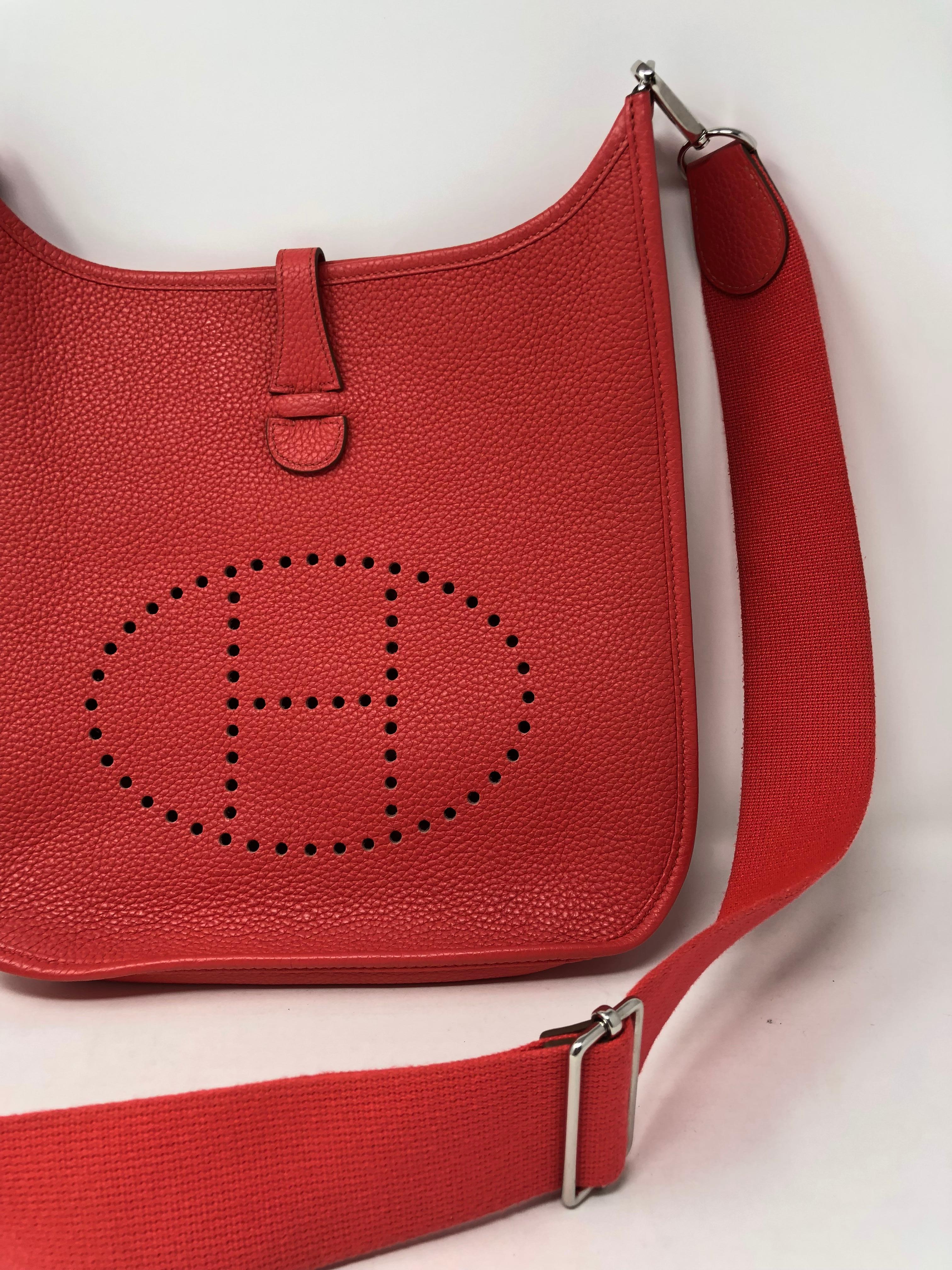 Hermes Evelyne GM in a coral/red color. Has pink hues in it. Mint condition crossbody that can be shortened. Series 3 Evelyne with the adjustable strap. Beautiful color that can bring a pop to any outfit. A favorite style among Hermes lovers. 