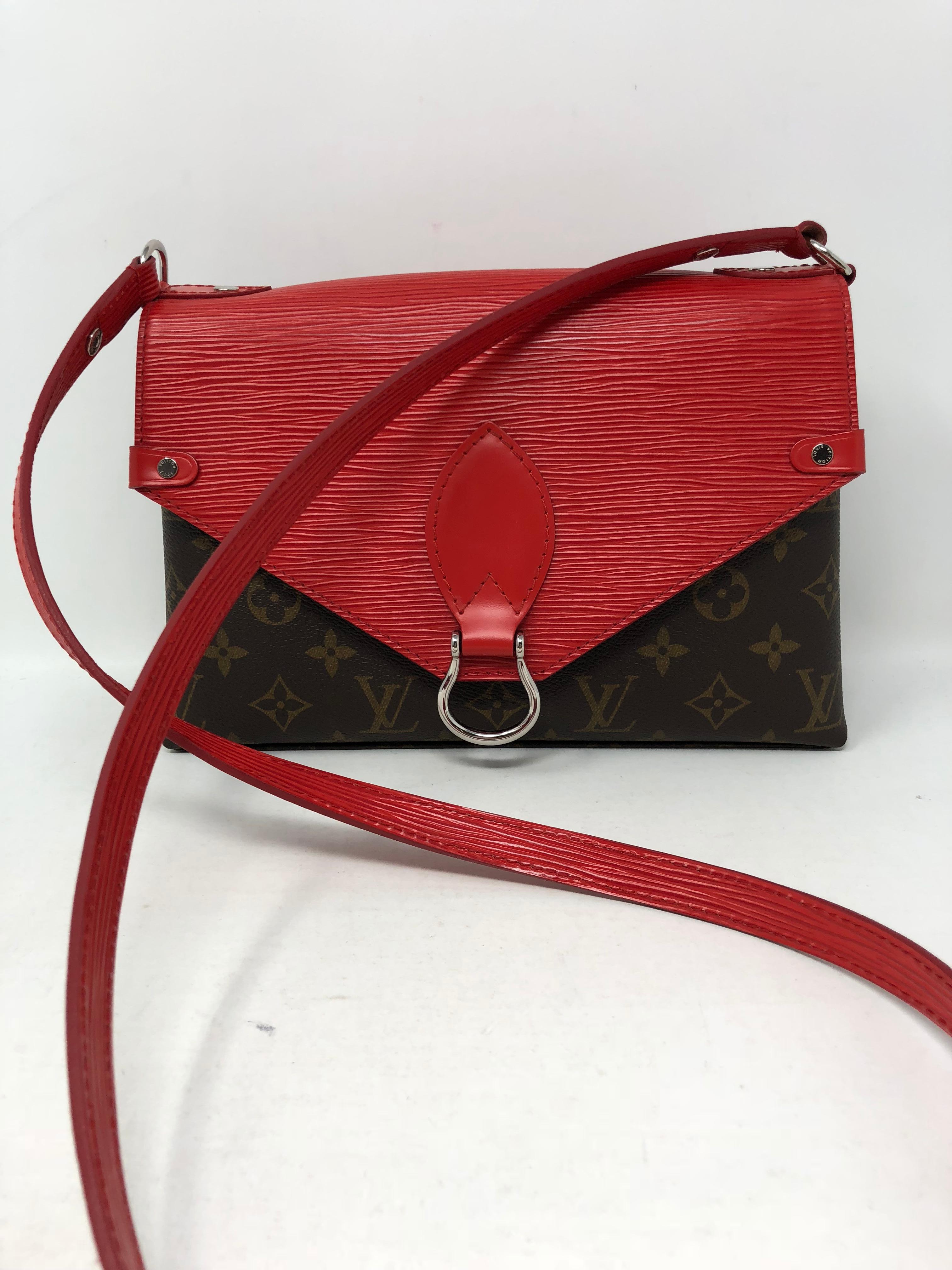 Louis Vuitton Saint Michel crossbody bag with red epi leather trim. Monogram canvas and epi leather marriaged together perfectly. This is a versatile bag. The strap can be adjusted to wear longer and shorter. Brand new and sold out at LV. Guaranteed