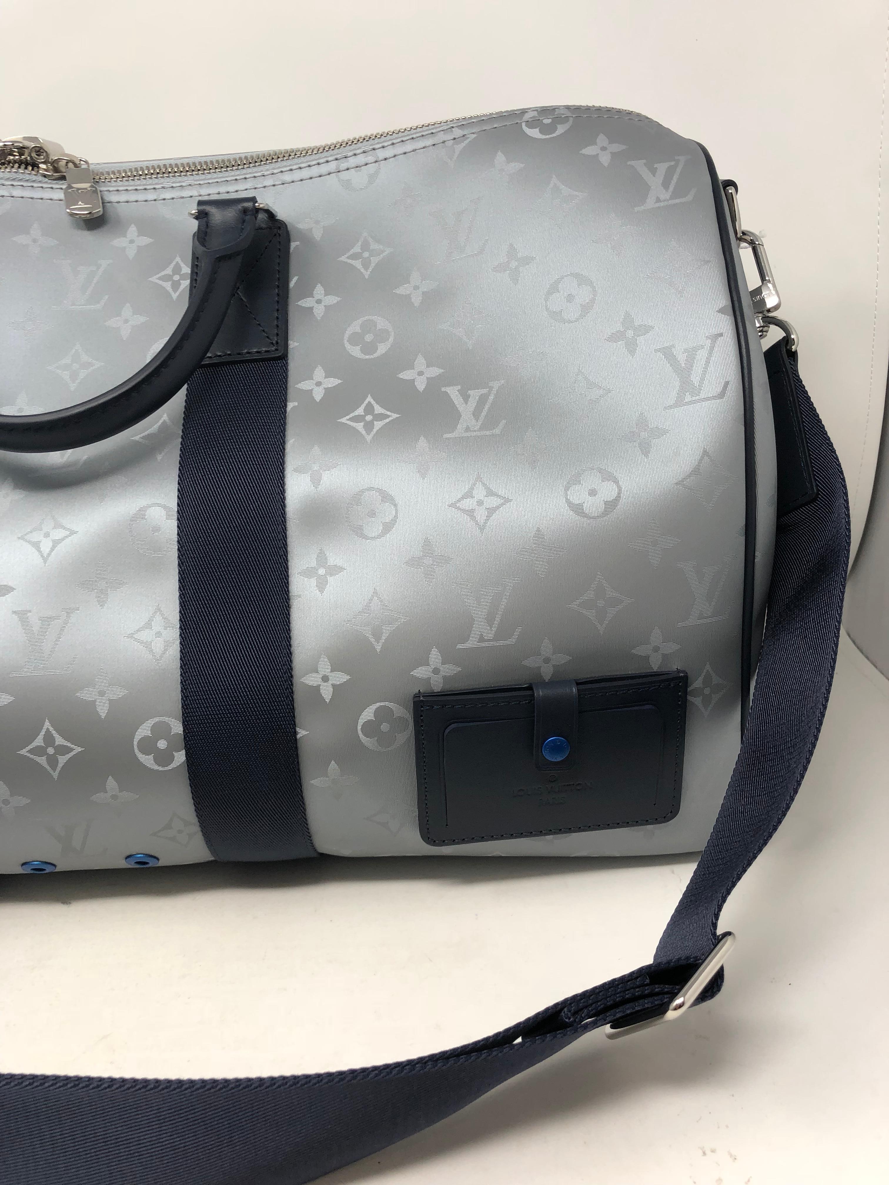 Louis Vuitton Monogram Satellite Keepall 50 in silver canvas. Pre-collection Spring-Summer 2019 from LV Men's artistic director Virgil Abloh. This collection gets you ready for Space Travel. Adjustable blue leather strap and detachable. Orange