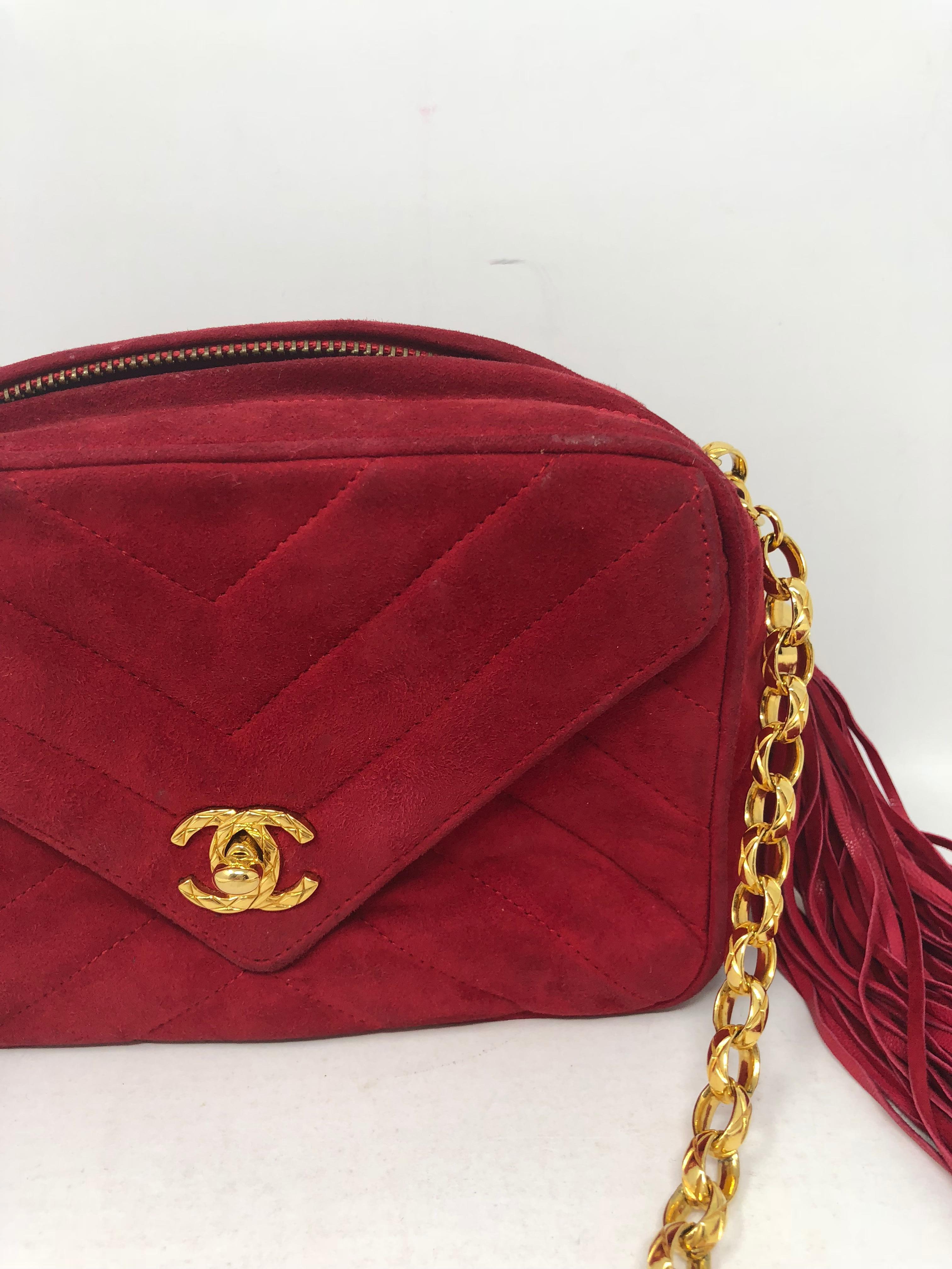 Chanel Red Suede Bag with Fringe Tassel. Vintage cherry red color with gold hardware. Chain is unique and a rare style. Suede has some wear with darker spots on back. Fair condition with lots of life left. The suede can be cleaned. The gold has not