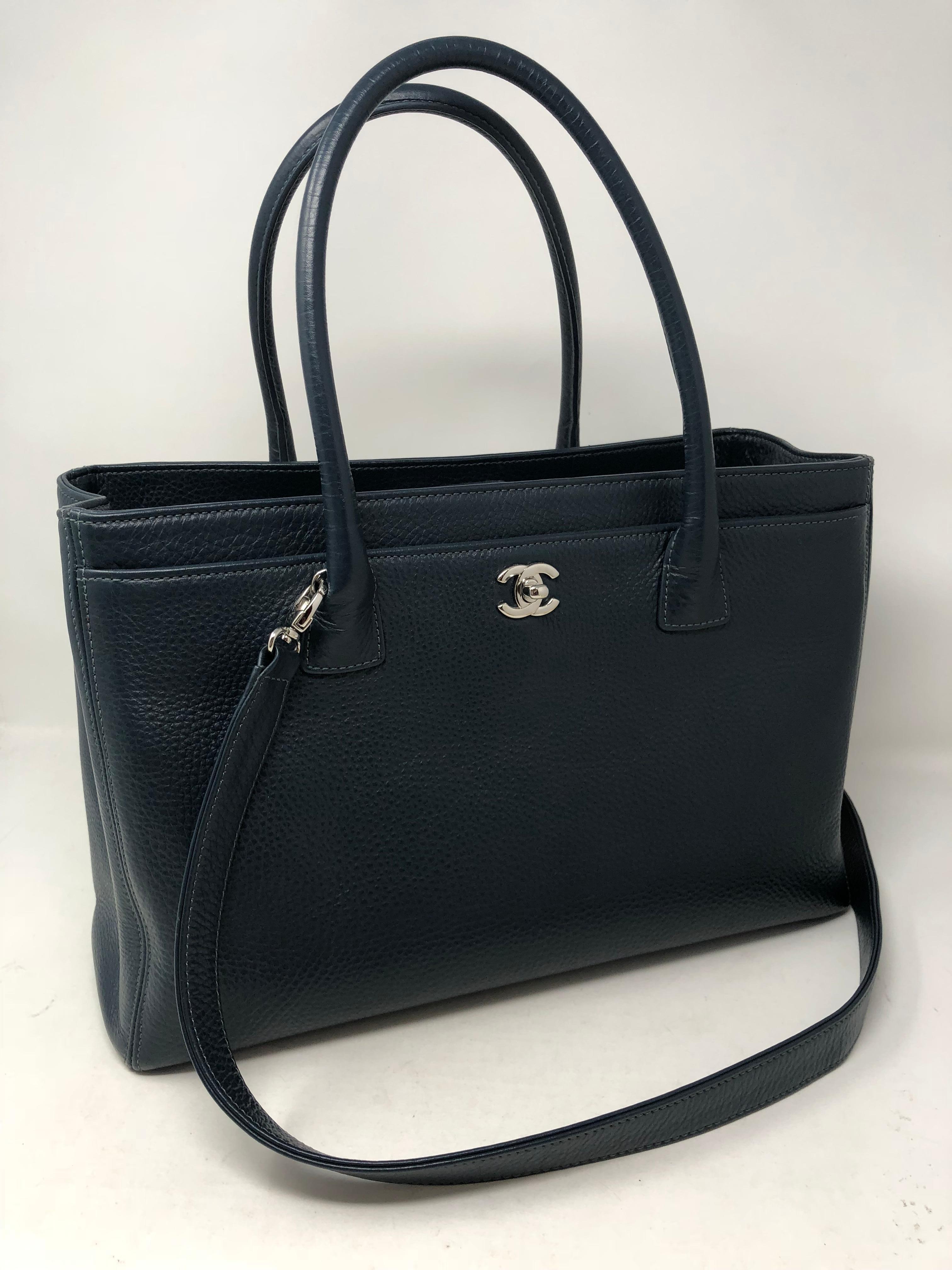 Chanel Blue Cerf Tote. Retired style from Chanel that includes an adjustable strap. Dark blue color that is beautiful. Can be worn without. Like new condition. Silver hardware. A classic style by Chanel. Guaranteed authentic. 