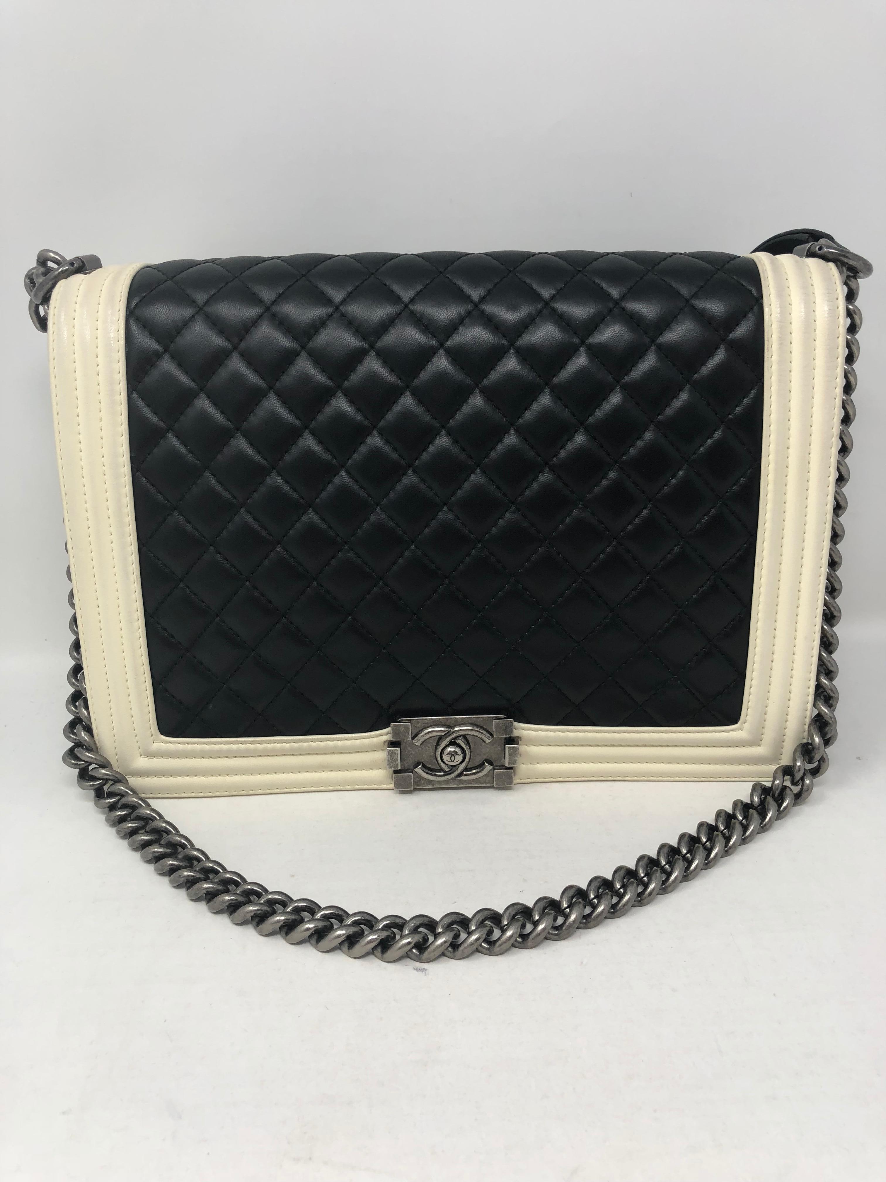 Chanel Black and White Boy Bag in Large size. Lambskin leather quilted with white trim. Antique silver hardware. Good condition with light wear on the white leather. Includes authenticity card and matching serial number inside the bag. Unique combo