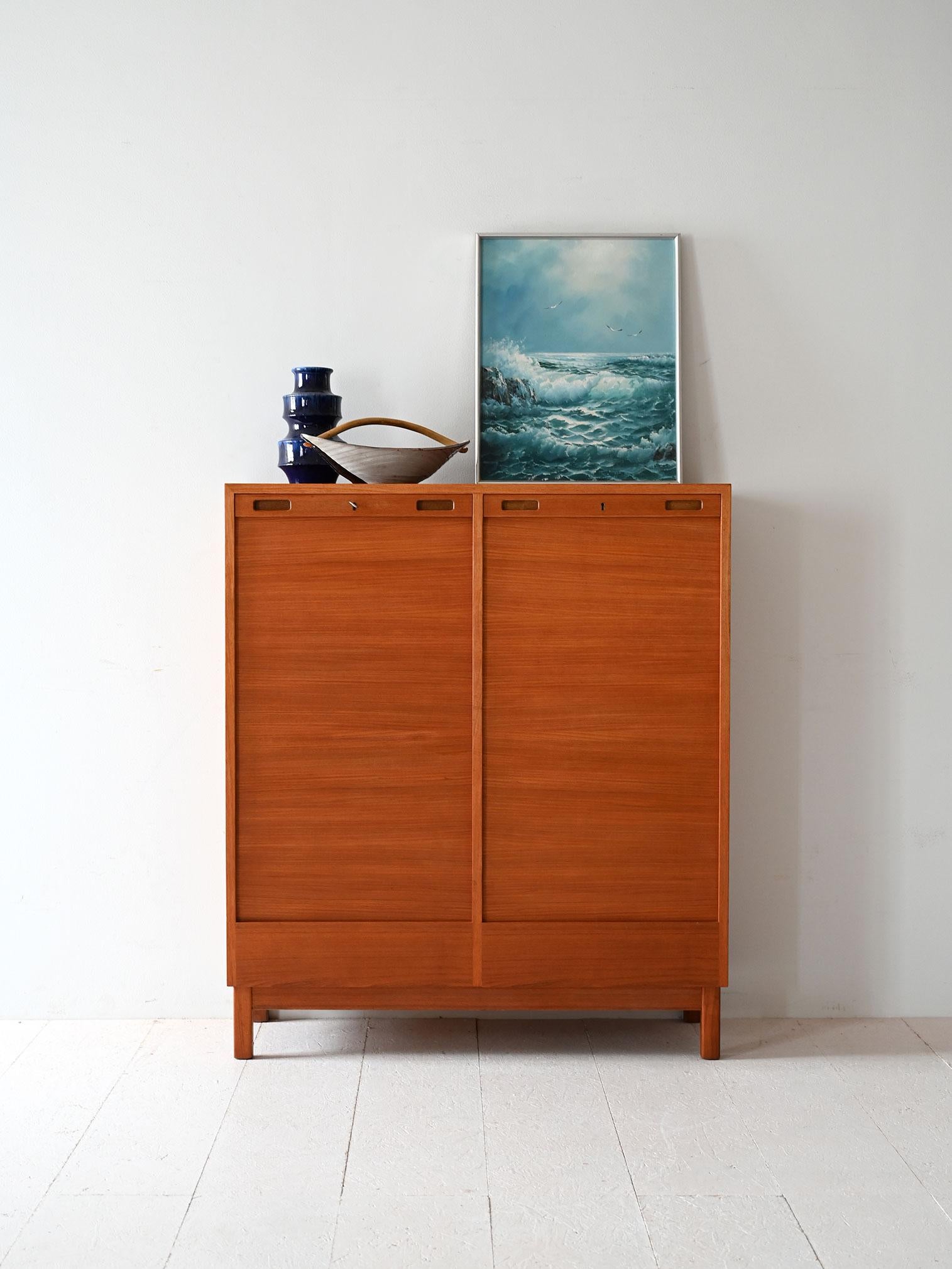 Scandinavian teak file cabinet with shutter doors, bottom drawers and interior shelves. Essential design with careful workmanship.

Scandinavian archives made in the 1950s or 1960s, with teak frame and shutter doors that open fully disappearing into