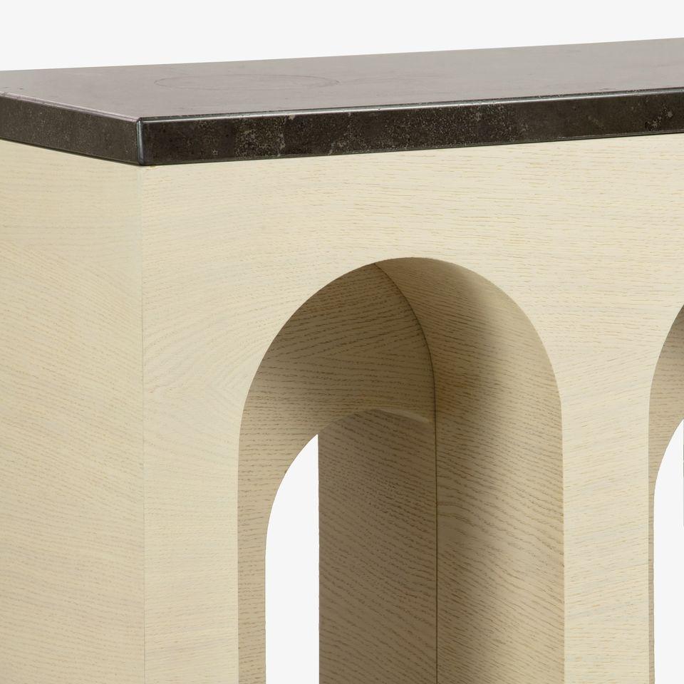 This console  is made of oak wood with a limed finish, which gives it a light and airy feel. The tabletop is made of marble, which adds a touch of luxury and sophistication. It has a rectangular shape with archways cut out of the front panel. The