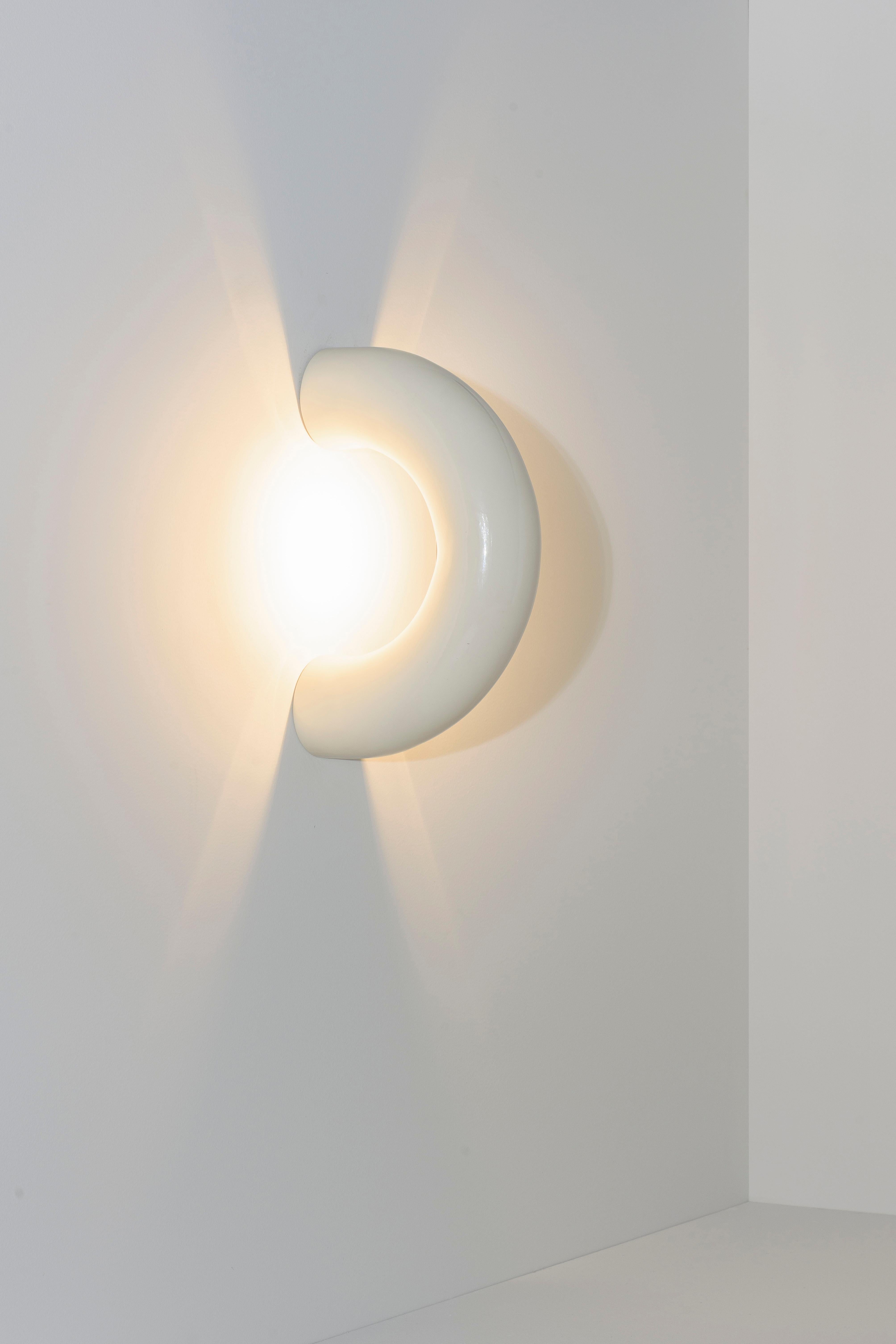 Die Arco-Lampen bestehen aus einem verlängerten Kreisausschnitt, der sich durch die Diskontinuität seiner Form auszeichnet. Die Collection'S besteht aus Lampen, die die Oberflächen, die sie berühren, zu durchdringen scheinen und sie sanft