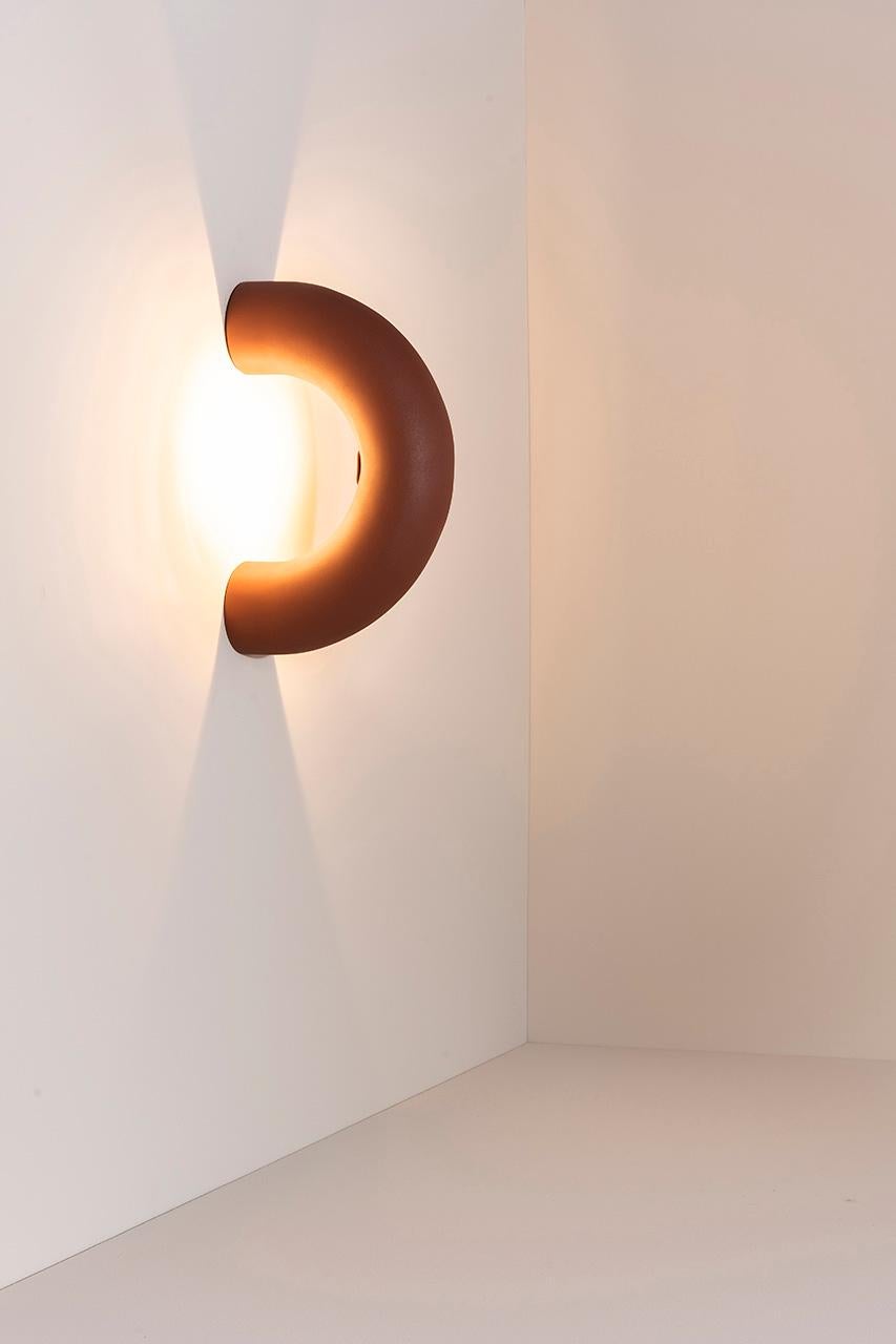 The Arco lamps are made from a prolonged section of circle that stand out by the discontinuity of its shape. The collection consists of lamps that seem to penetrate the surfaces they touch, illuminating them delicately. The light focus frames the