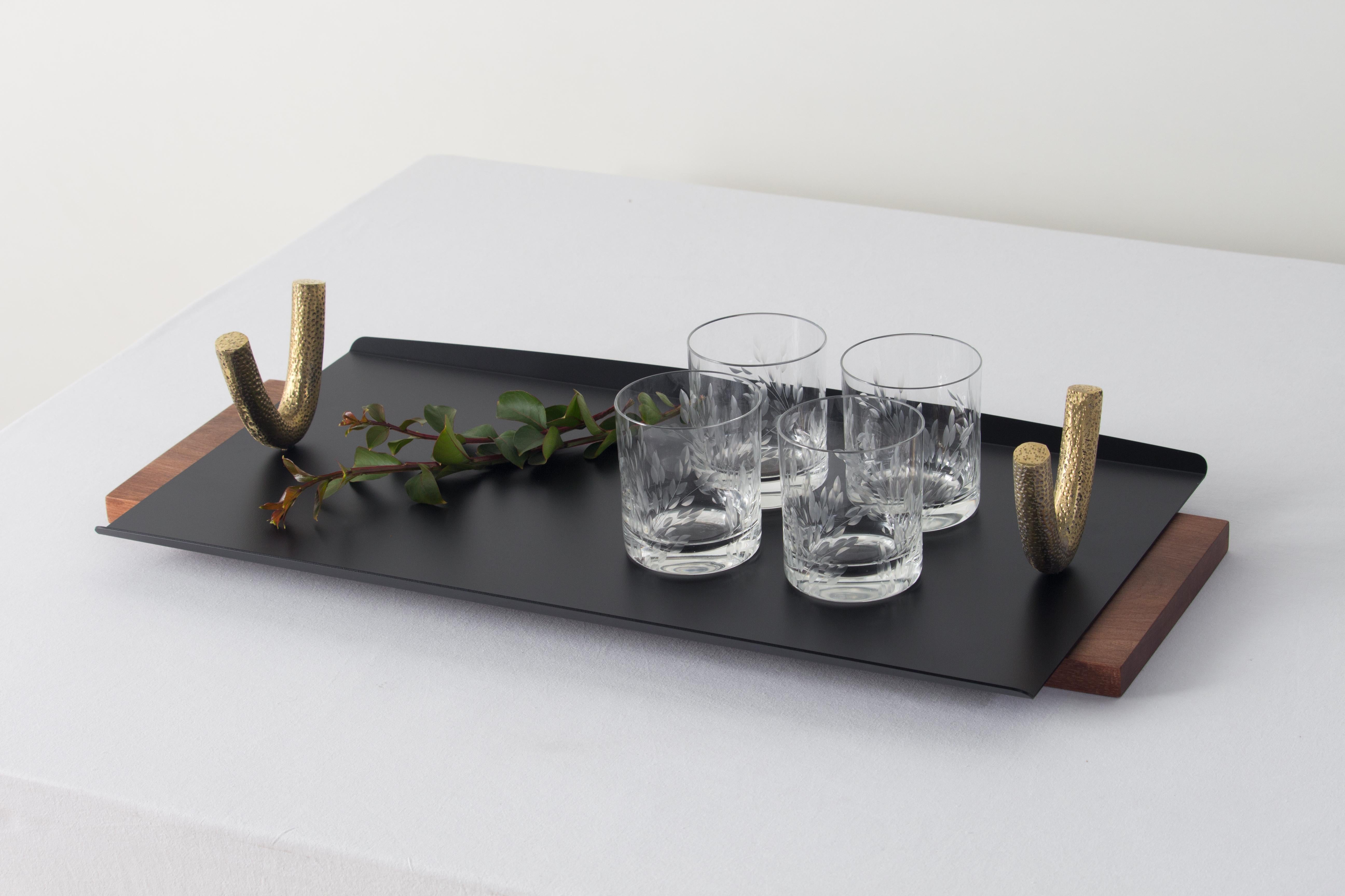 Comprising six containers, two trays and three hangers, the Arco Collection has as a main element the cast metal arcs. The molds for these pieces were manually sculpted out of wood, carrying a texture that grants an organic irregularity to these
