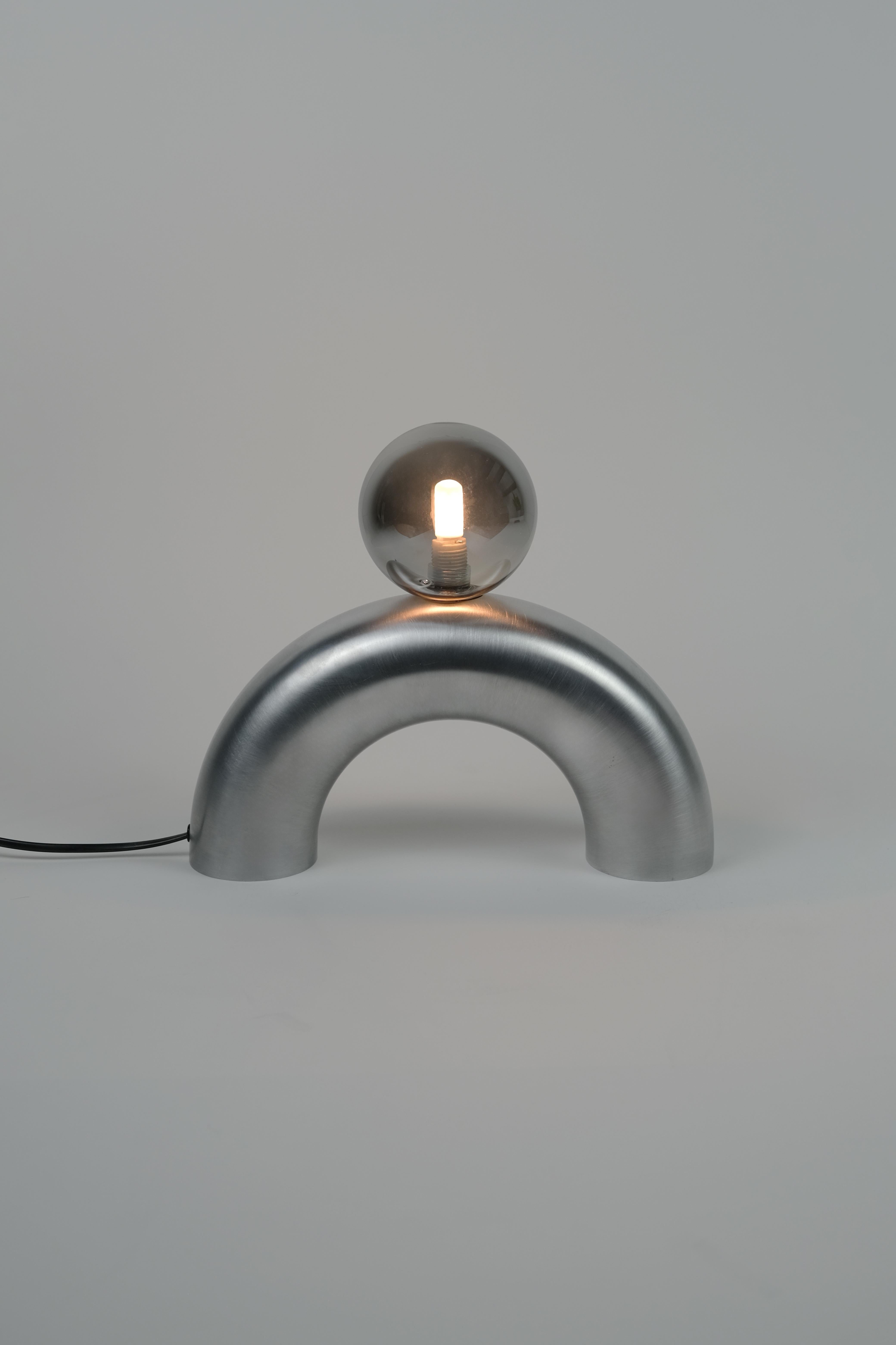 Lampe à poser Arcora par Heako Studio
Édition limitée.
Dimensions : Ø 30,5 x H 26,7 cm : Ø 30,5 x H 26,7 cm.
Matériaux : Aluminium.

Toutes nos lampes peuvent être câblées en fonction de chaque pays. Si elle est vendue aux États-Unis, elle sera