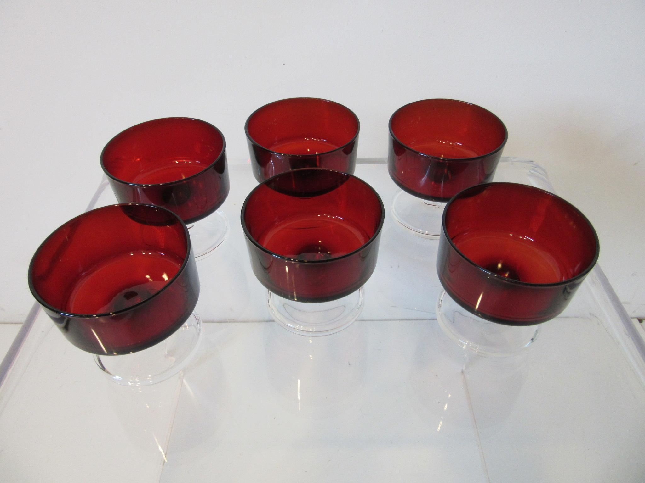 Un juego de seis copas de postre transparentes de color rojo rubí intenso, fabricadas y marcadas en Francia, perfectas para la cena, que dan un toque de color a los platos blancos o a la vajilla de color liso. Pesan mucho y están muy equilibradas,