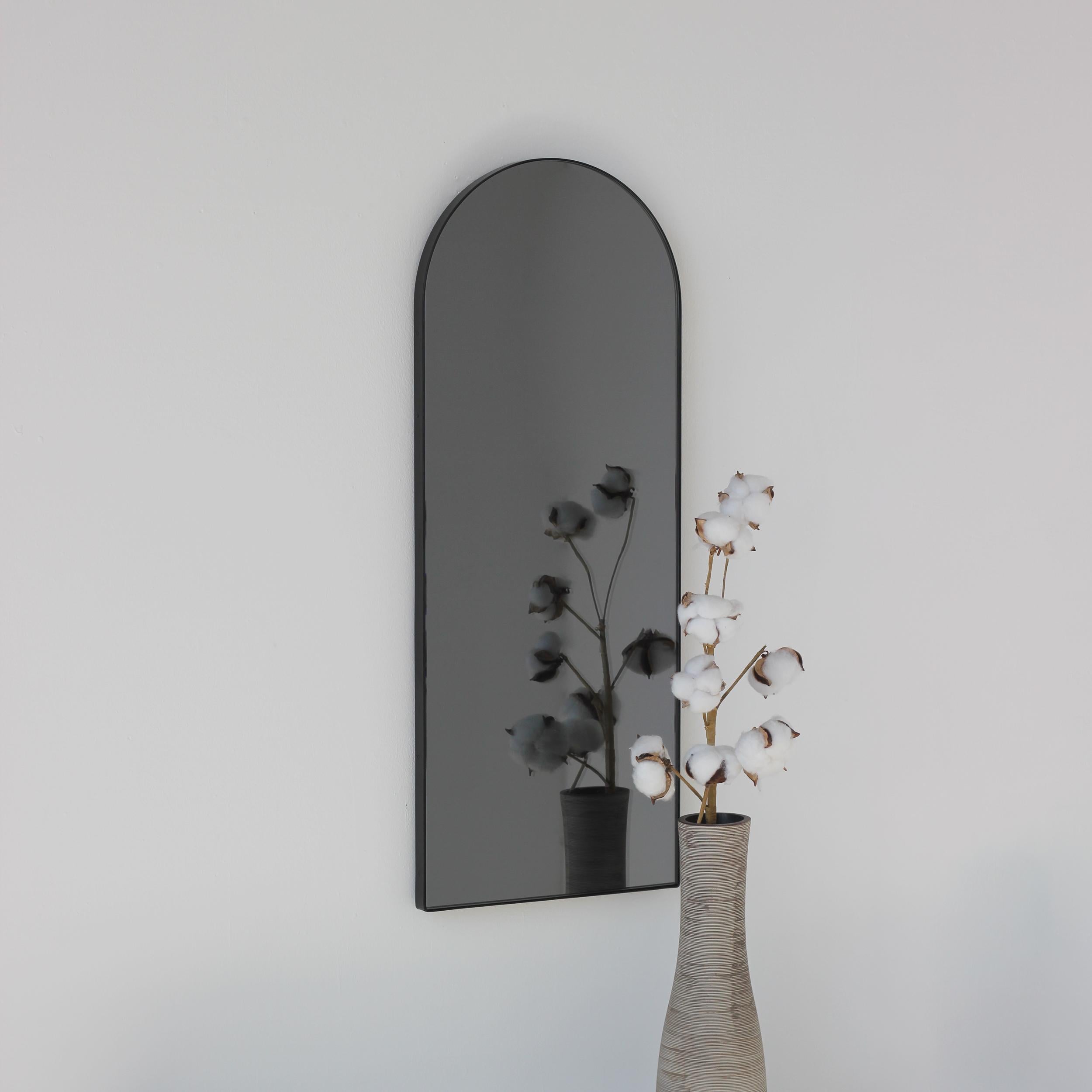 Moderner bogenförmiger, schwarz getönter Spiegel mit elegantem schwarzem Rahmen. Entworfen und handgefertigt in London, UK.

Die mittelgroßen, großen und extragroßen Spiegel (37 cm x 56 cm, 46 cm x 71 cm und 48 cm x 97 cm) sind mit einem