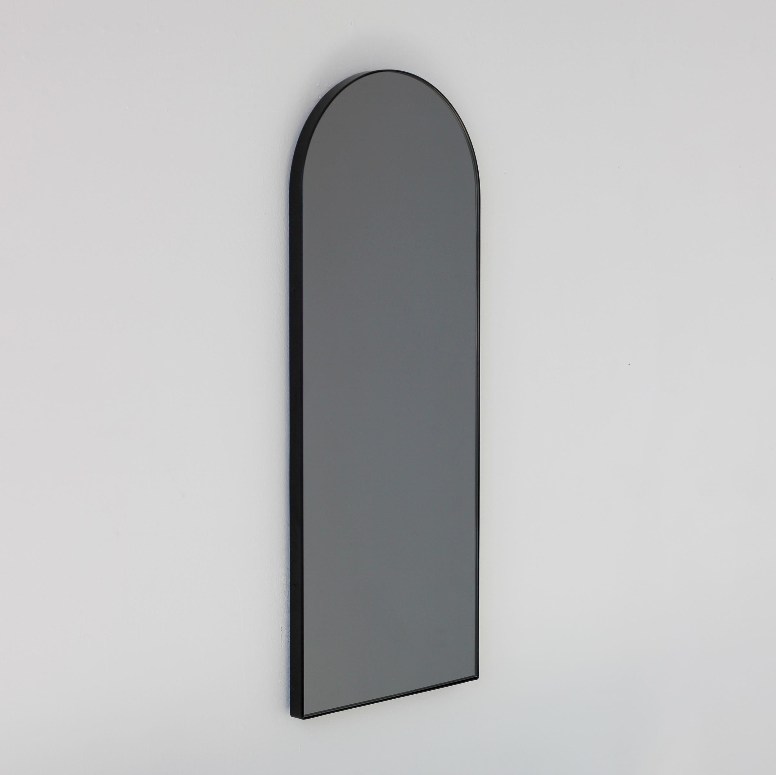 Zeitgenössischer Arcus™ bogenförmiger, schwarz getönter Spiegel mit einem eleganten schwarzen Rahmen. Entworfen und handgefertigt in London, UK.

Unsere Spiegel sind mit einem integrierten französischen Befestigungssystem (geteilte Leisten)