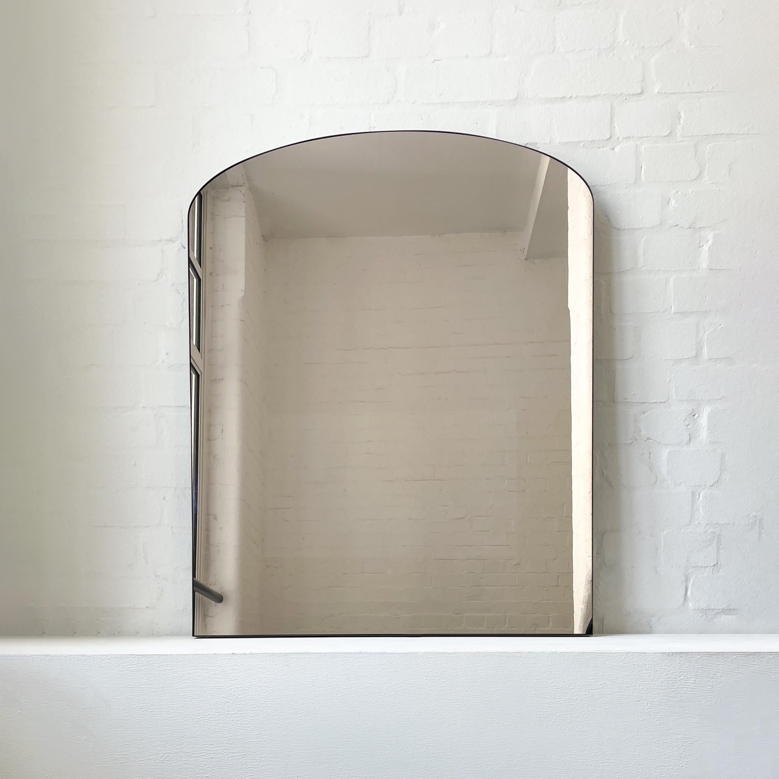 Specchio Arcus�™ contemporaneo a forma di arco con cornice in ottone massiccio con finitura in patina di bronzo e specchio color bronzo. Progettato e realizzato a mano a Londra, nel Regno Unito. Questo specchio è completamente