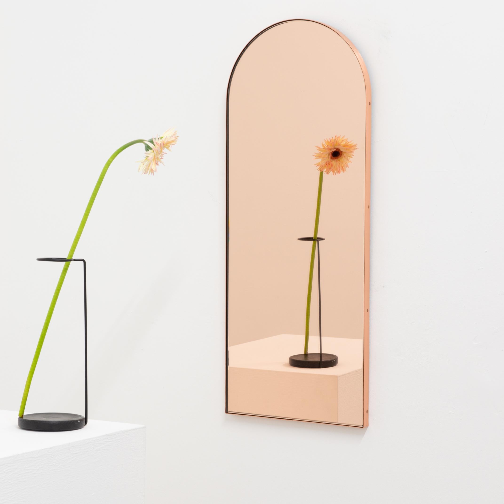 Minimalist arch shaped rose gold/peach mirror with an elegant copper frame. Designed and handcrafted in London, UK. The detailing and finish, including copper plated visible screws, emphasise the Craft and quality feel of the mirror, a true