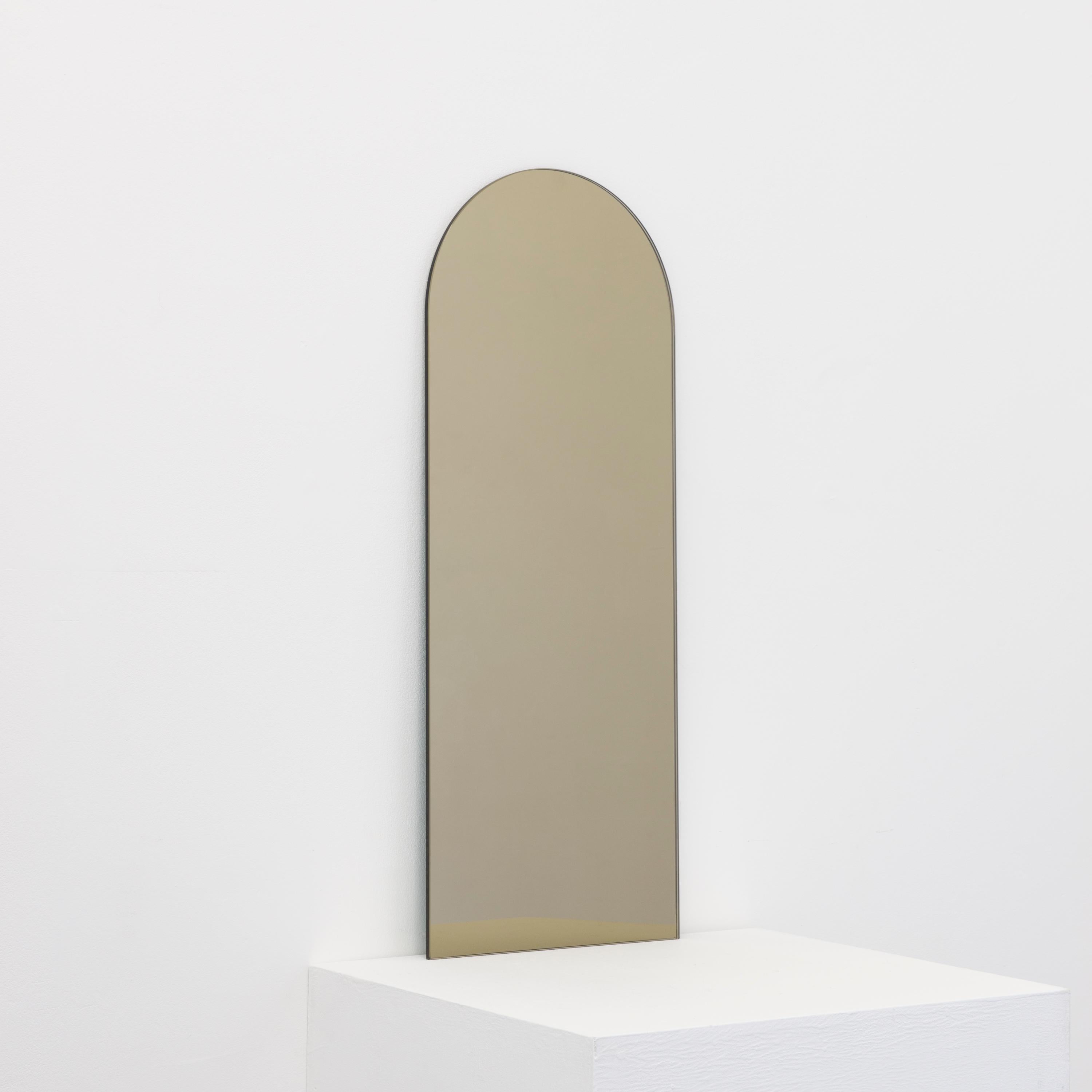 Minimalist arch shaped frameless bronze tinted mirror with a floating effect. Quality design that ensures the mirror sits perfectly parallel to the wall. Designed and made in London, UK.

Fitted with professional plates not visible once installed