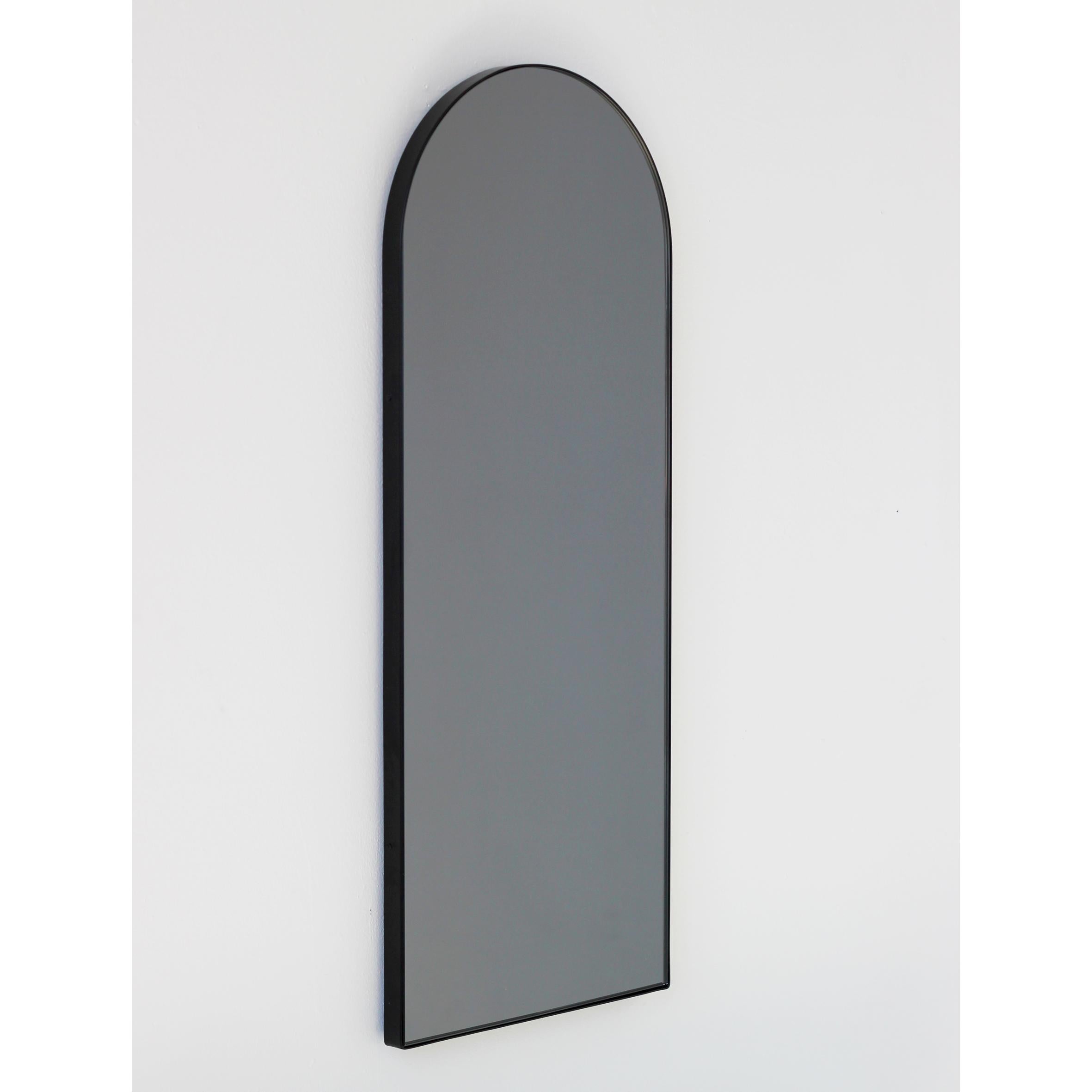 Moderner bogenförmiger, schwarz getönter Spiegel mit elegantem schwarzem Rahmen. Entworfen und handgefertigt in London, UK.

Die mittelgroßen, großen und extragroßen Spiegel (37 cm x 56 cm, 46 cm x 71 cm und 48 cm x 97 cm) sind mit einem