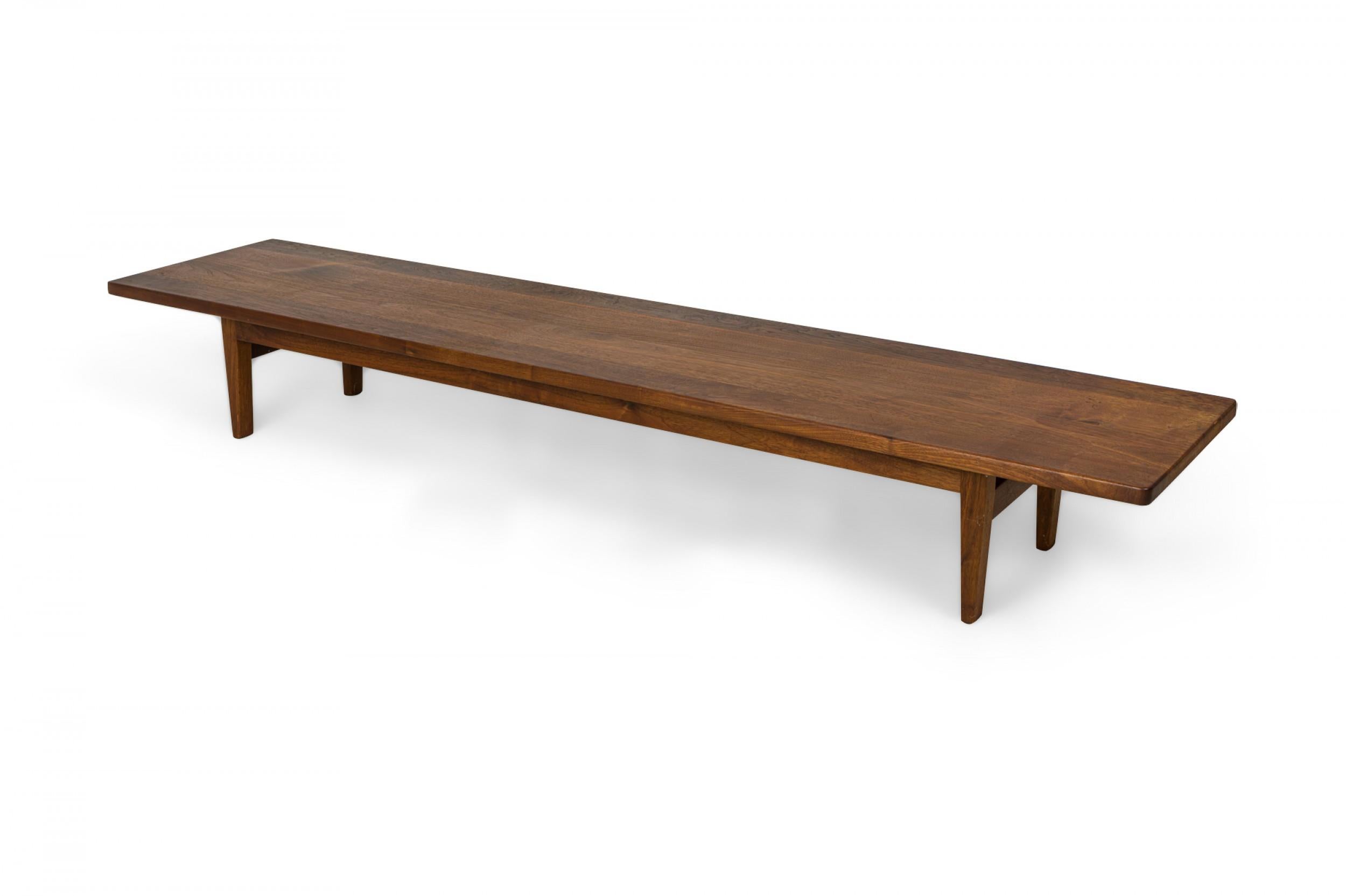 American mid-century low table with an elongated rectangular plank surface resting on four slightly tapered squared legs. (ARDEN RIDDLE)