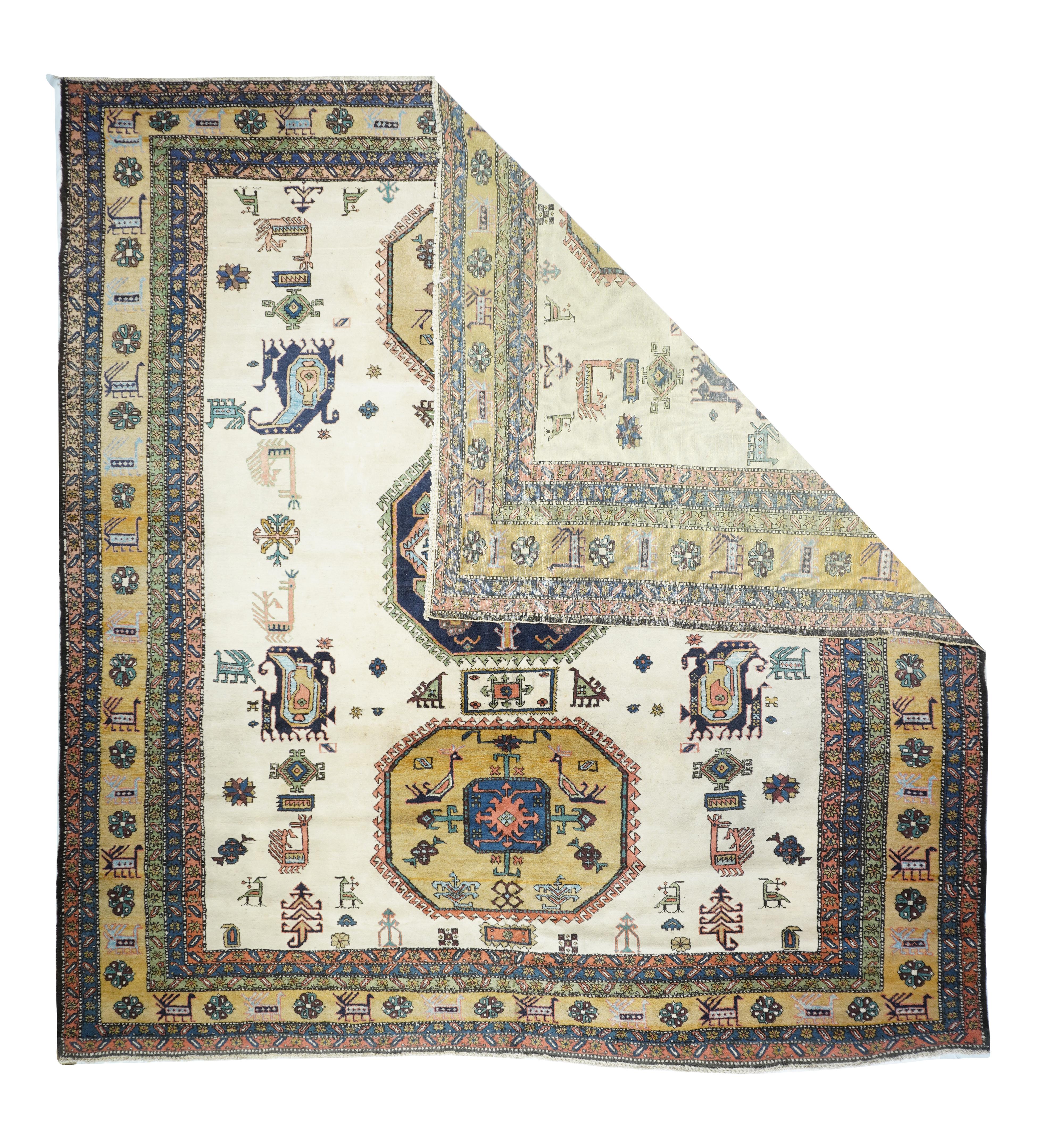 In a post-WWII Caucasian style, with three octagonal medallions dark slate blue and rusty goldenrod, with internal bird and octagon décor, on a sandy grounds, with boteh and rooster secondary forms. Straw border with animal and rosettes. Cotton