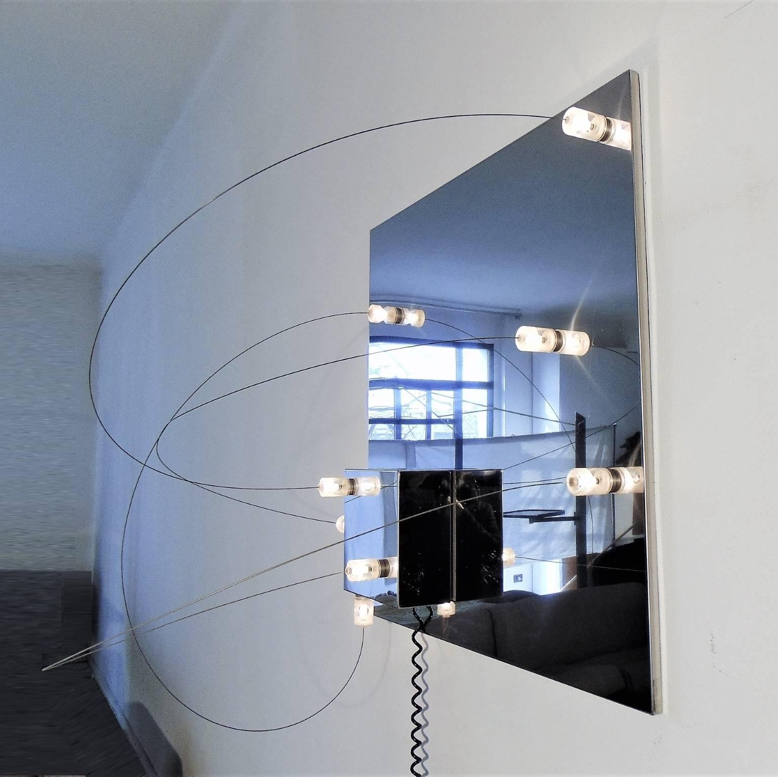 Aplique pequeño, modular, escultural y de bajo voltaje, de acero inoxidable, con ocho luces, según catálogo de 1972, con cilindros de metacrilato magnéticos y móviles y un cubo móvil, que puede separarse de la placa principal y recolocarse con