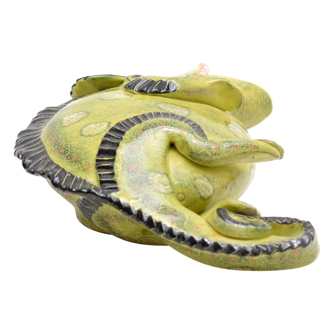 In the verdant landscapes of South Africa, Ardmore Ceramics births a wonder: the Lizard Sculpture. Crafted by the hands of Somandla Ntshalintshali and painted by the talented Misiwe Hadebe Ntshalinsthali, it stands 2 inches tall, stretching 5 inches