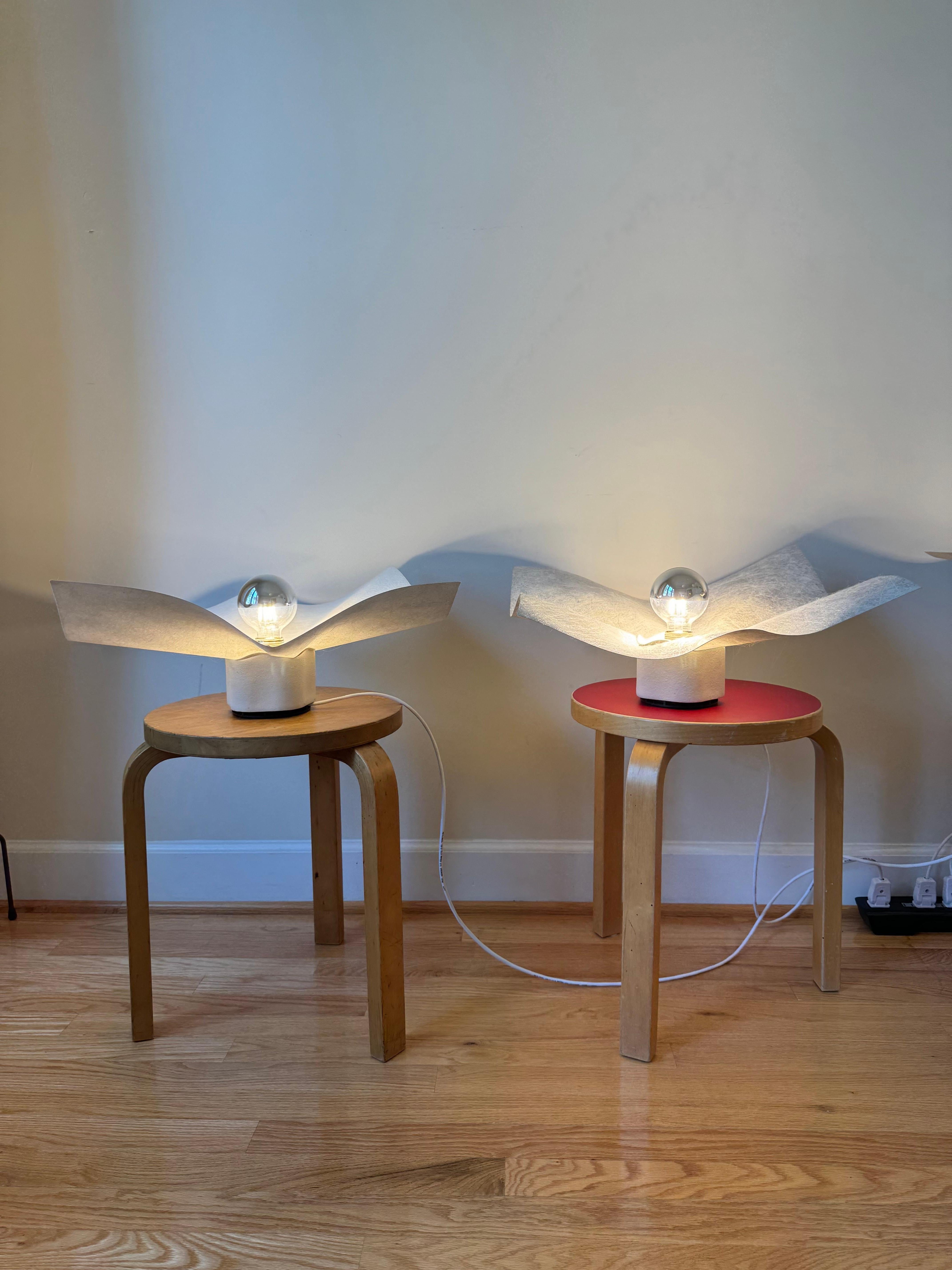 The Area 50 table lamp is part of a series of table, floor, wall and ceiling lamps designed by Mario Bellini in 1974 for Artemide. 
Bellini says he designed the lamps in relation to the immaterial nature of light, so rather than creating an object,