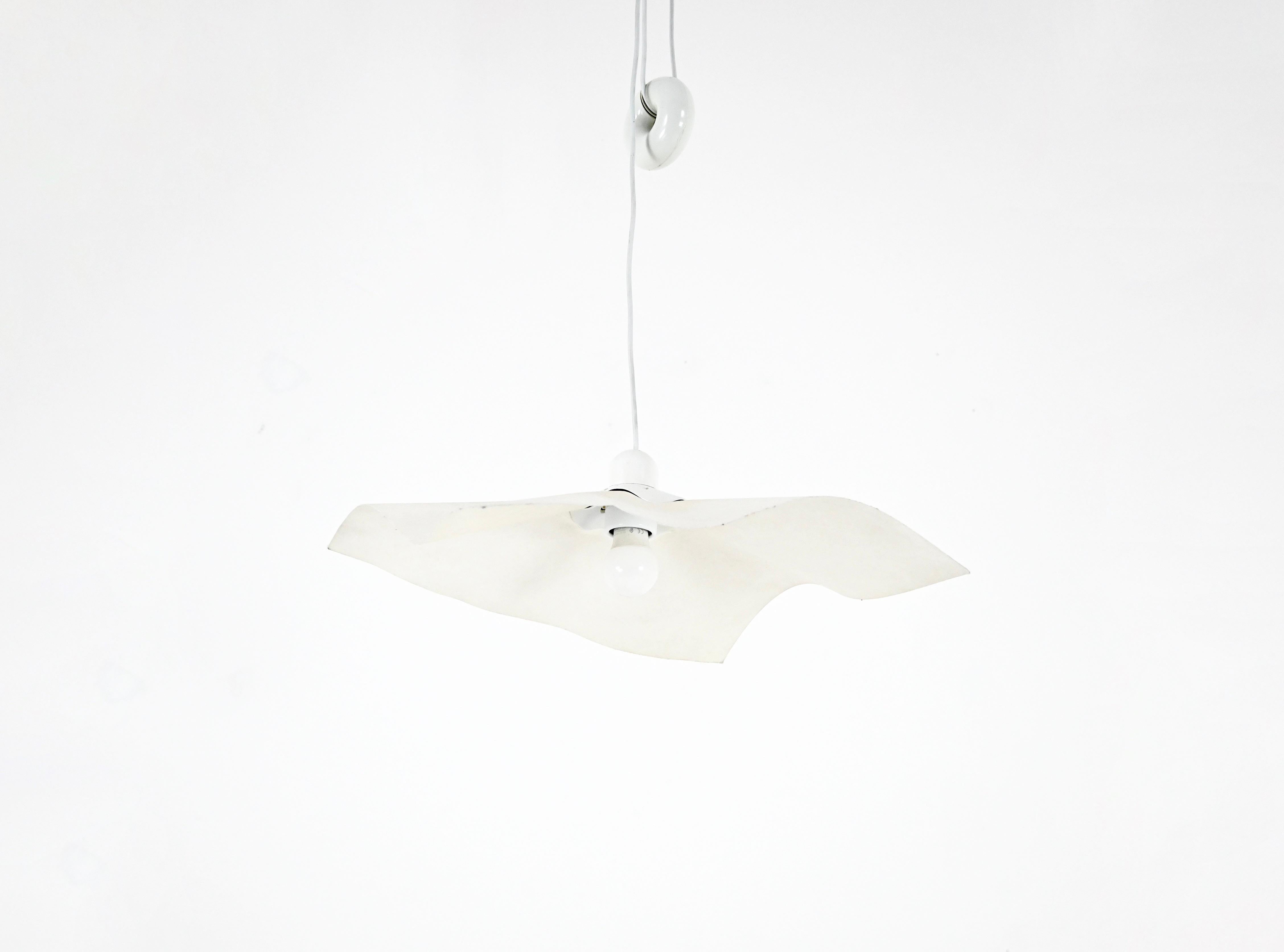 Lampada a sospensione in carta e plastica di Mario Bellini con contrappeso a forma di ciambella, modello: Area 50. Facilmente regolabile in altezza. Altezza minima con cuneo: 70 cm, altezza massima con cavo: 150 cm. Usura dovuta al tempo e