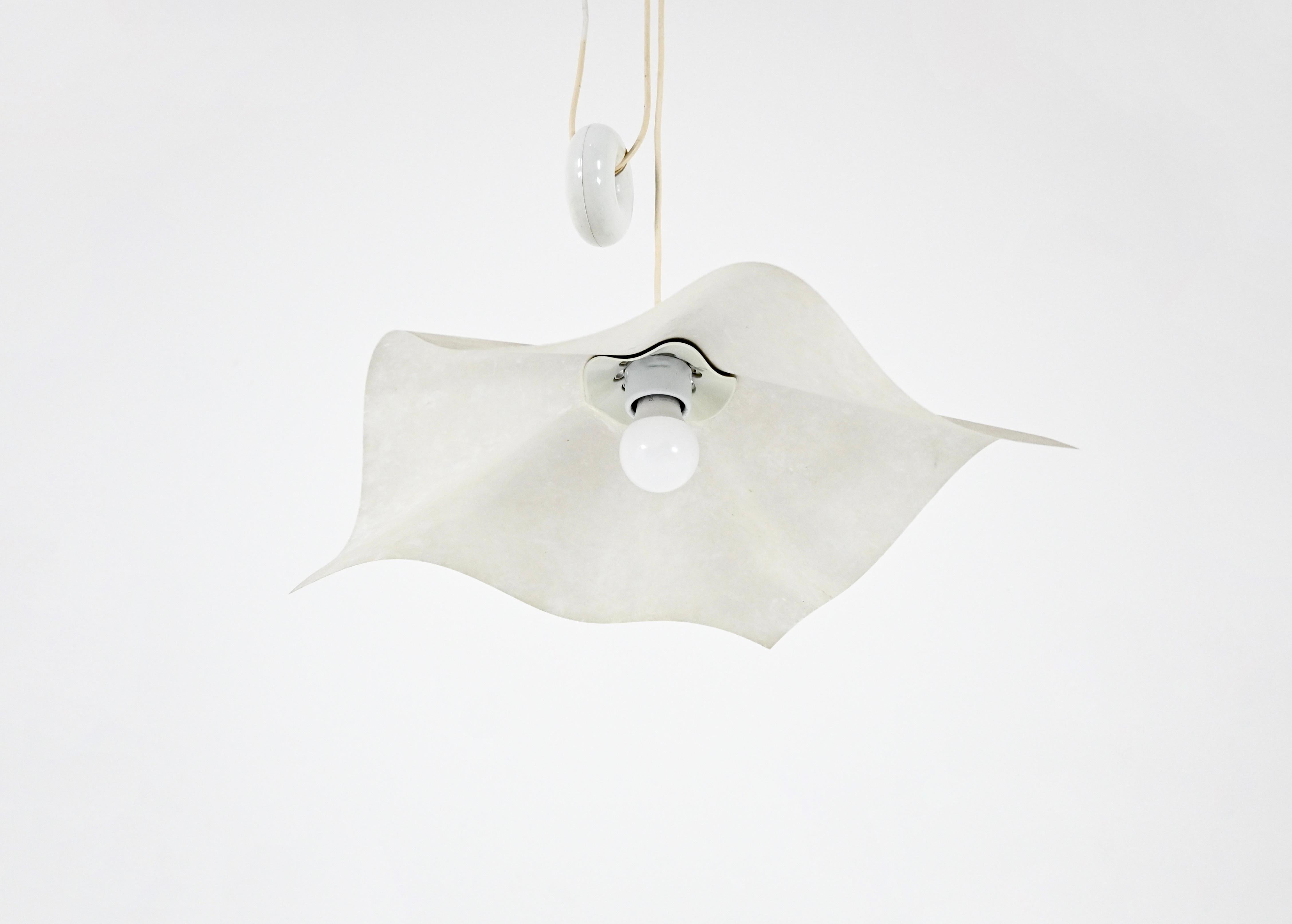 Lampada a sospensione in carta e plastica di Mario Bellini con contrappeso a forma di ciambella, modello: Area 50. Facilmente regolabile in altezza. Altezza minima con cuneo: 100 cm, altezza massima con cavo: 270 cm. Usura dovuta al tempo e