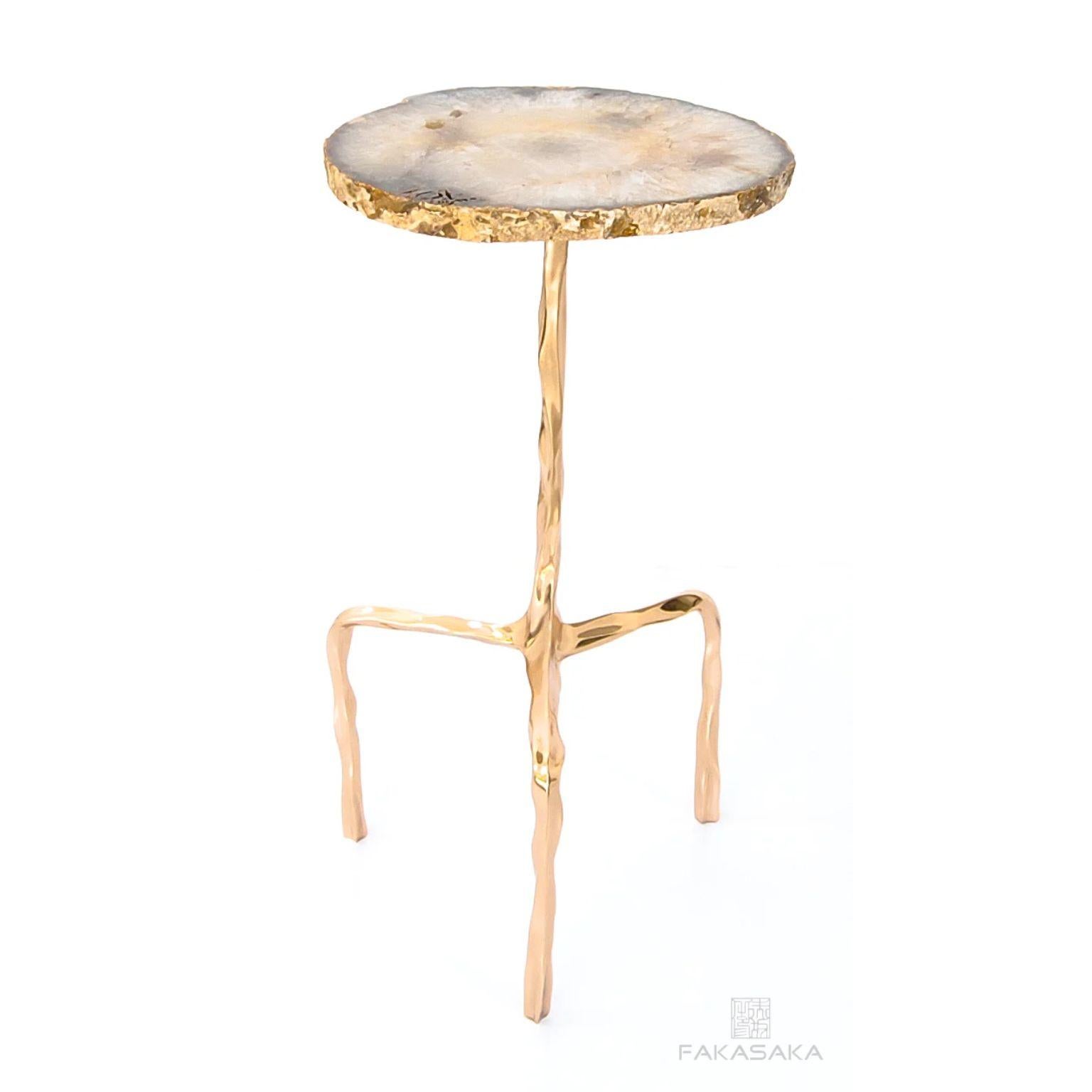Aretha drink table with Agate top by Fakasaka Design.
Dimensions: W 30 cm D 30 cm H 58 cm.
Materials: polished bronze base, Agate top.
 
Also available in different table top materials:
Nero Marquina Marble 
Marrom Imperial Marble
Pedra