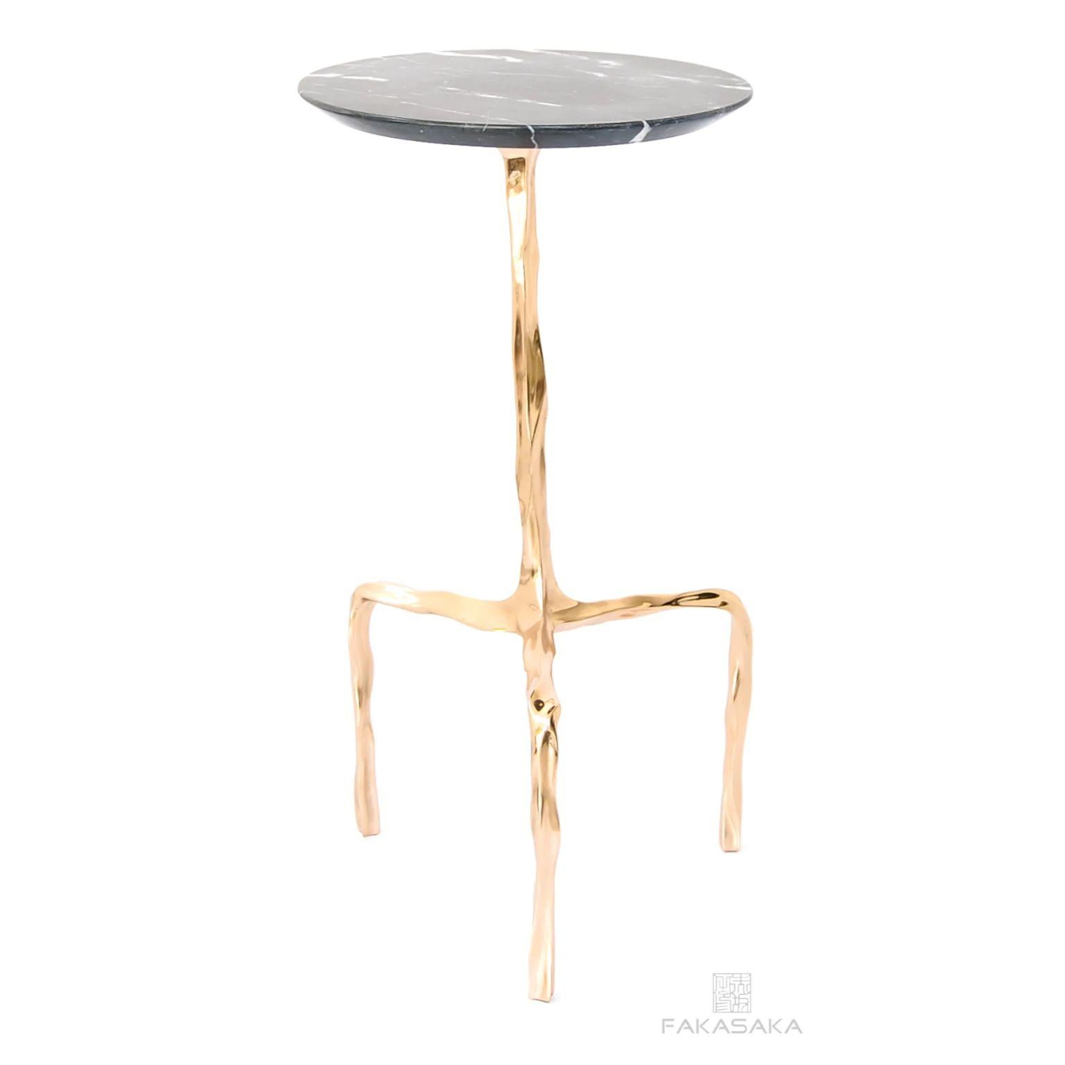 Aretha drink table with Nero Marquina Marble top by Fakasaka Design.
Dimensions: W 30 cm D 30 cm H 58 cm.
Materials: polished bronze base, Nero Marquina marble top.
 
Also available in different table top materials:
Nero Marquina Marble