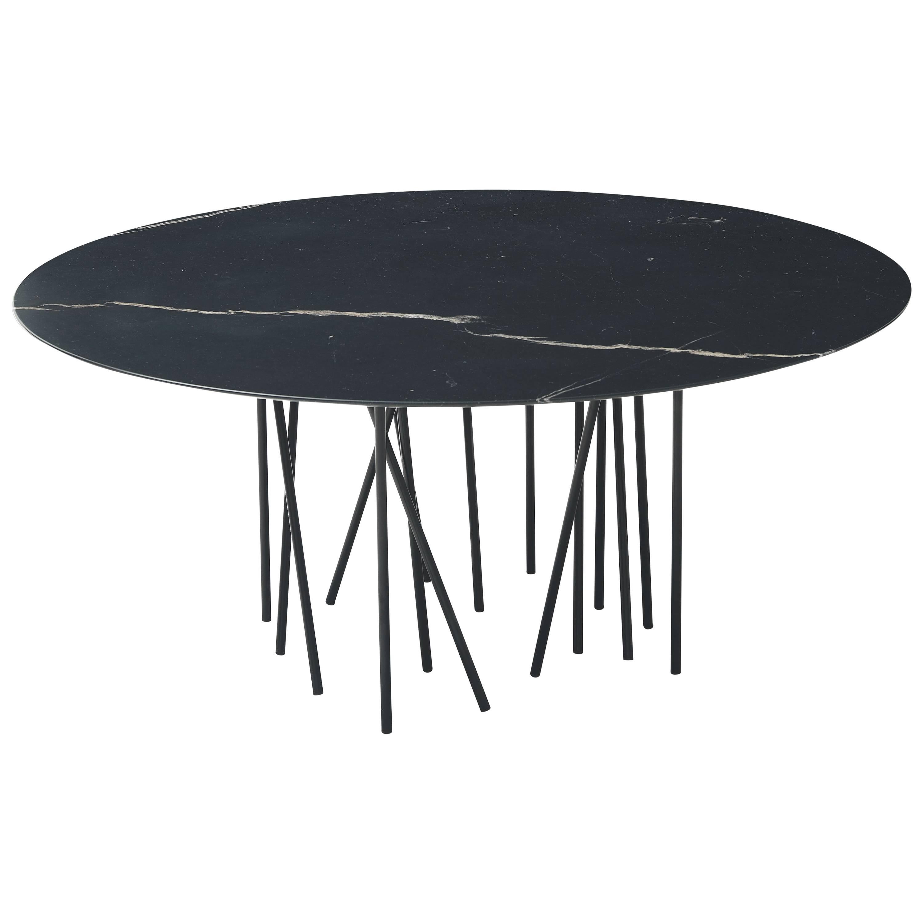 The shape is inspired by the sea creatures, statuesque and sinuous, with tentacles to support the top. It seems to be an improvised table, with a light and minimal look, where the thin stands, apparently posed in a casual way, oppose themselves to