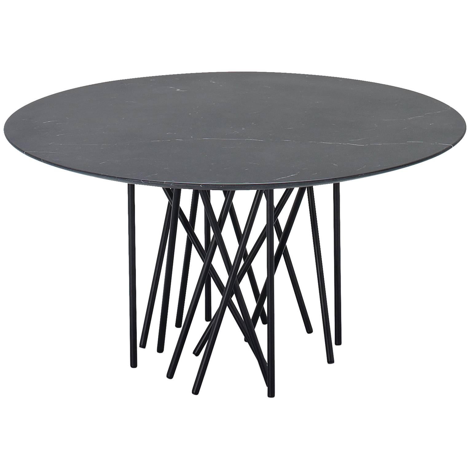 The shape is inspired by the sea creatures, statuesque and sinuous, with tentacles to support the top. It seems to be an improvised table, with a light and minimal look, where the thin stands, apparently posed in a casual way, oppose themselves to
