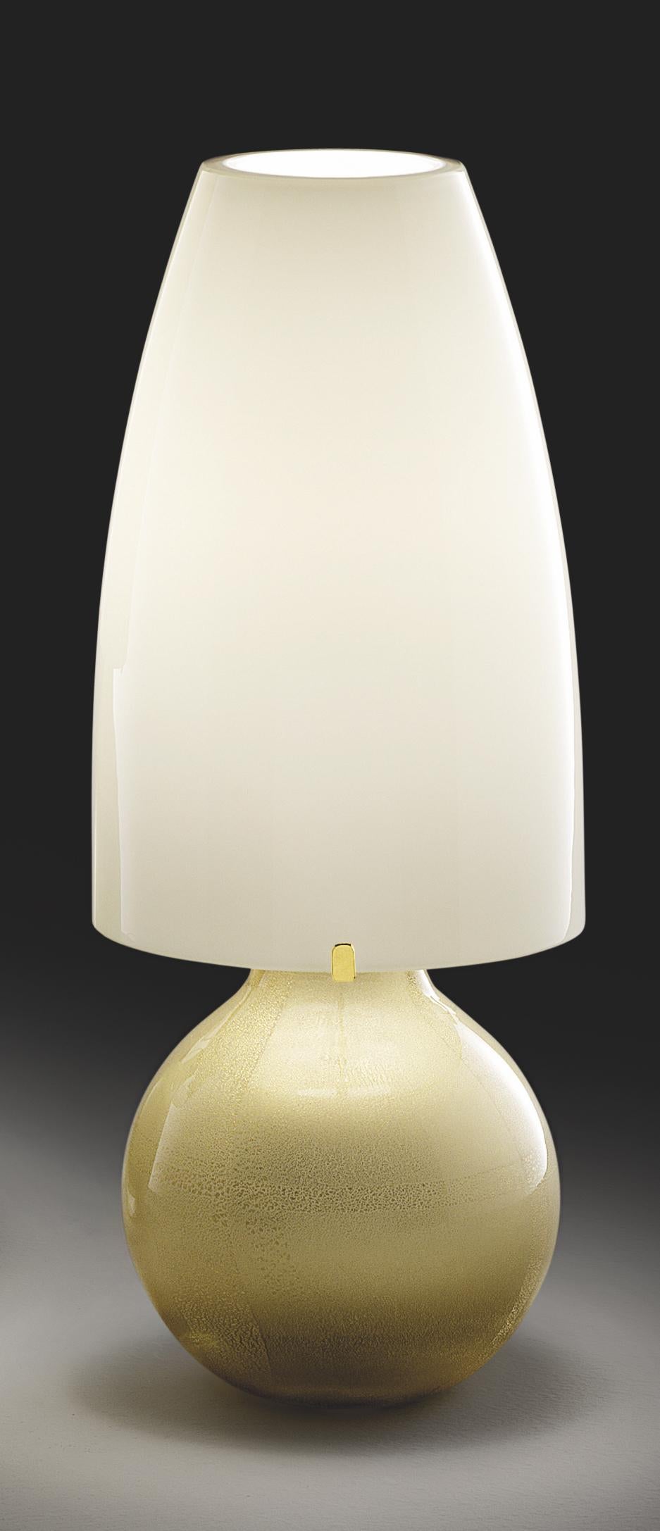 Table lamp in handblown glass with submerged gold leaves and gold plated metal finishes. Beautiful atop any table, desk or credenza. Also available in various sizes and colors.

Light source: One max 100 W E27. Dimensions: 15.5 cm diameter x 37 cm