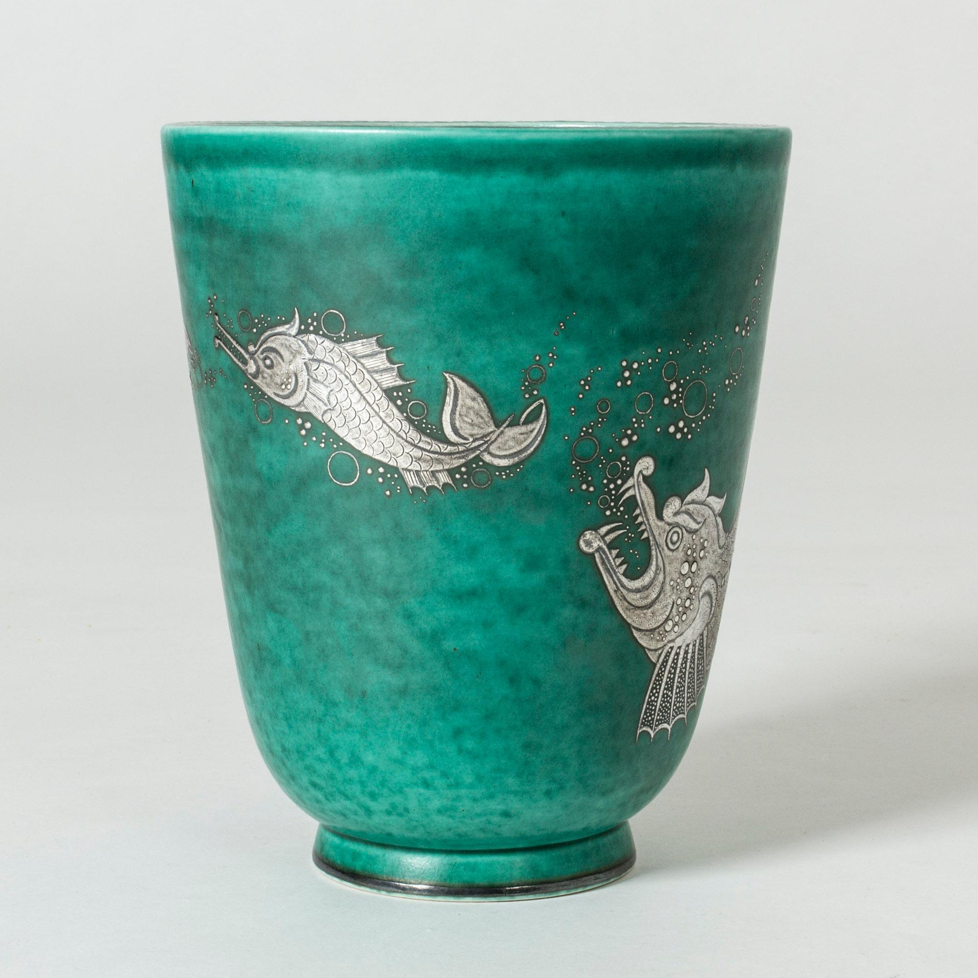 Stoneware “Argenta” vase by Wilhelm Kåge with an amazing silver decor of a big fish chasing a smaller fish, chasing a smaller fish. Lovely attention to every detail, scales and bubbles.
“Argenta” was introduced at the Stockholm exhibition in 1930