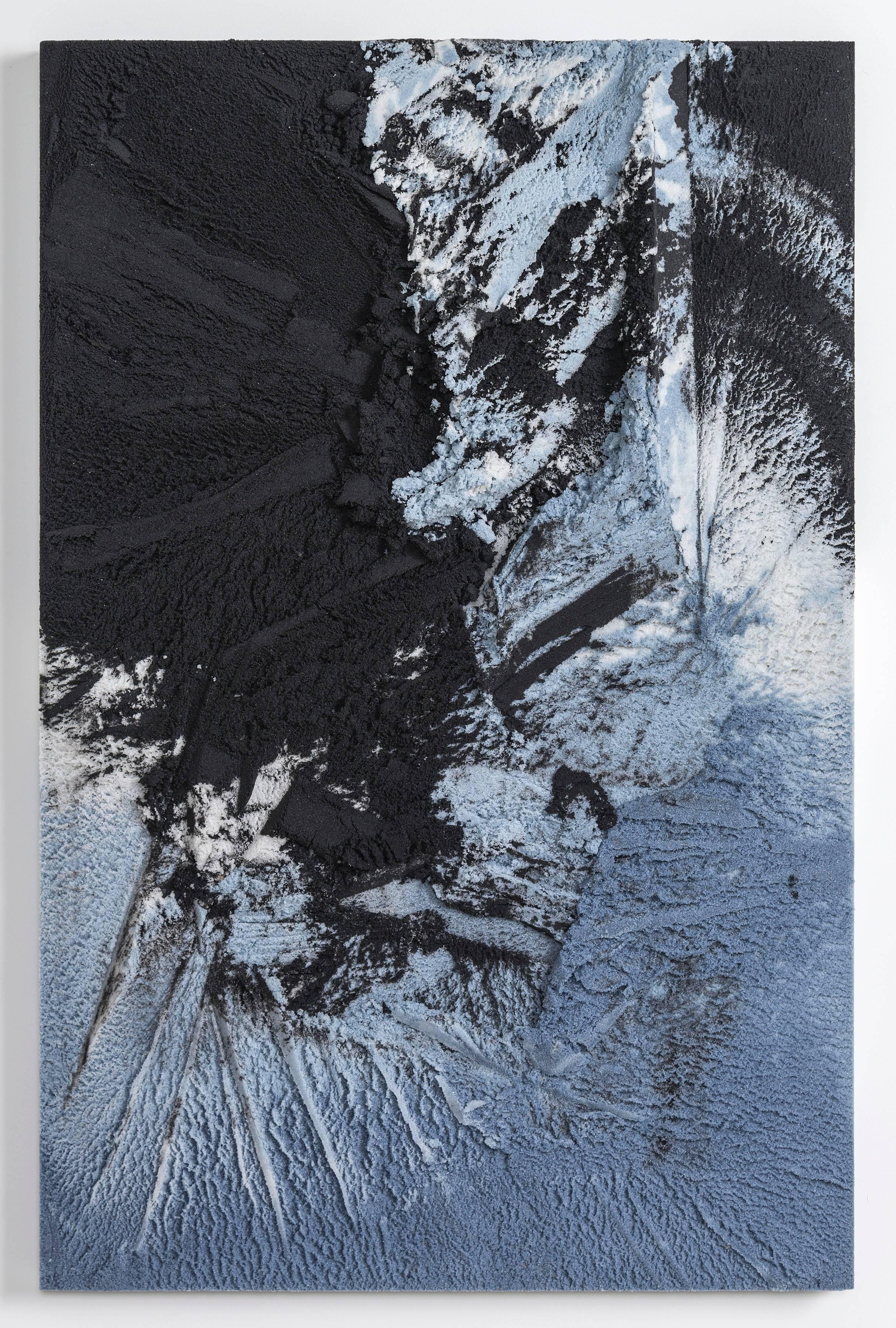 Composed in a language of landscape-oriented abstraction, the painting is made entirely from powdered glass. With hand-dyed granules in black, blue, and white tones, the materials create an effect evocative of aerial views of a rugged landscape and