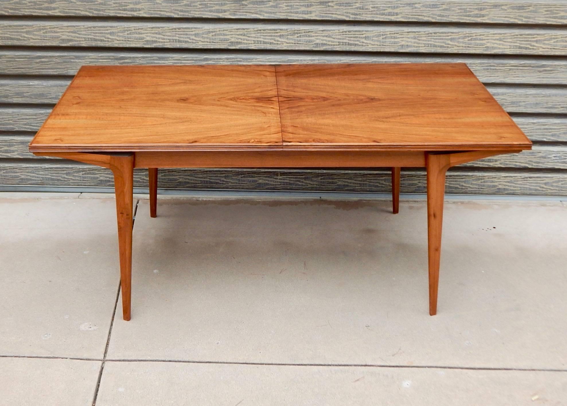 Argentine Mid-Century Modern extendable dining table rendered in highly figured walnut. The table has a concealed leaf which can be opened to extend this table to 83 inches. Restored and with some minor surface scratches. Please see photos for more
