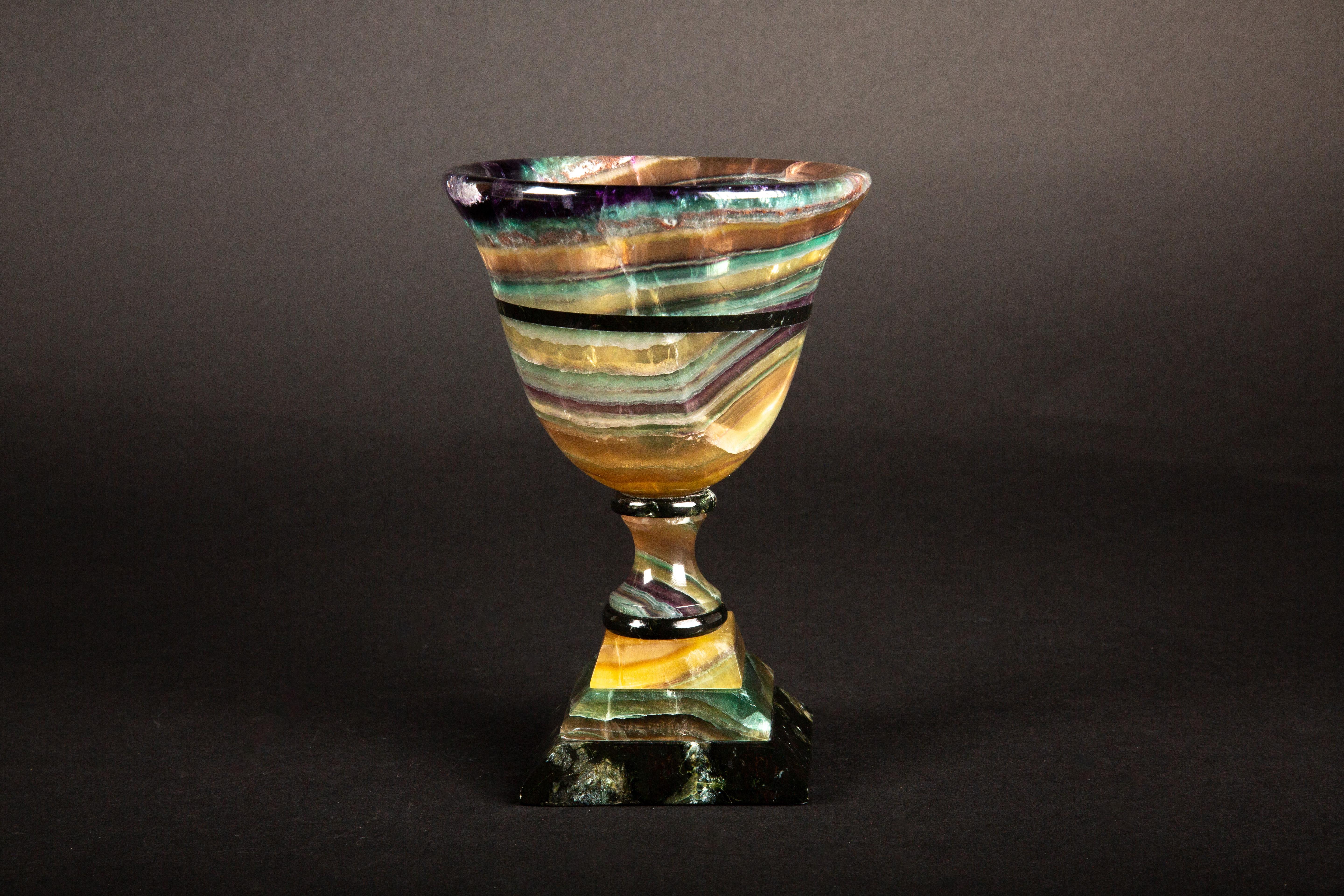 Crafted by skilled artisans in Argentina, this exquisite hand-carved chalice/cup showcases the captivating beauty of multi-colored fluorite. Originating from the depths of the earth, fluorite's unique hues swirl together in mesmerizing patterns,