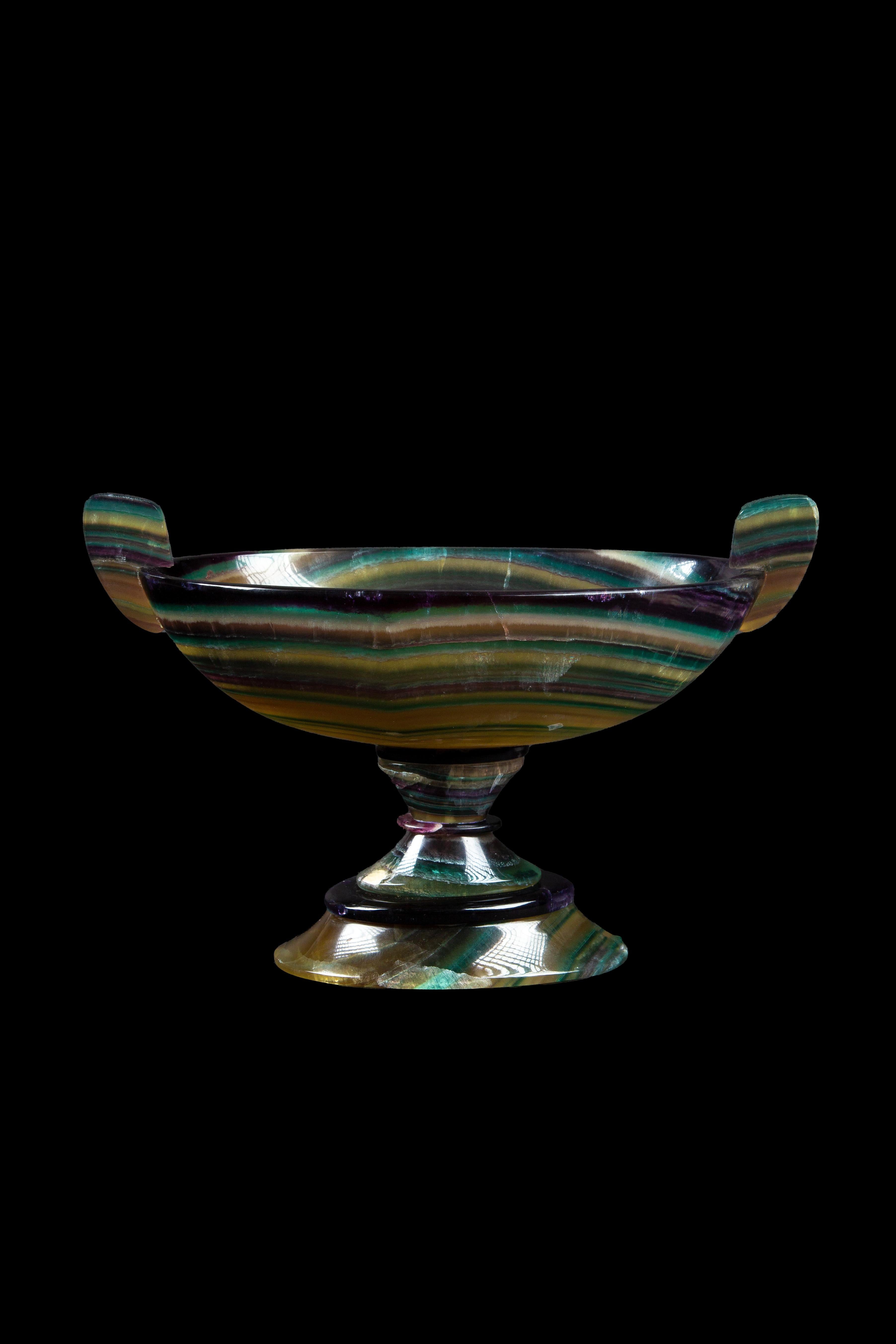Exquisite craftsmanship of this hand-carved vessel hailing from the artisanal workshops of Argentina. Crafted from natural Fluorite, renowned for its captivating hues and inherent beauty, this vessel transcends mere functionality to become a
