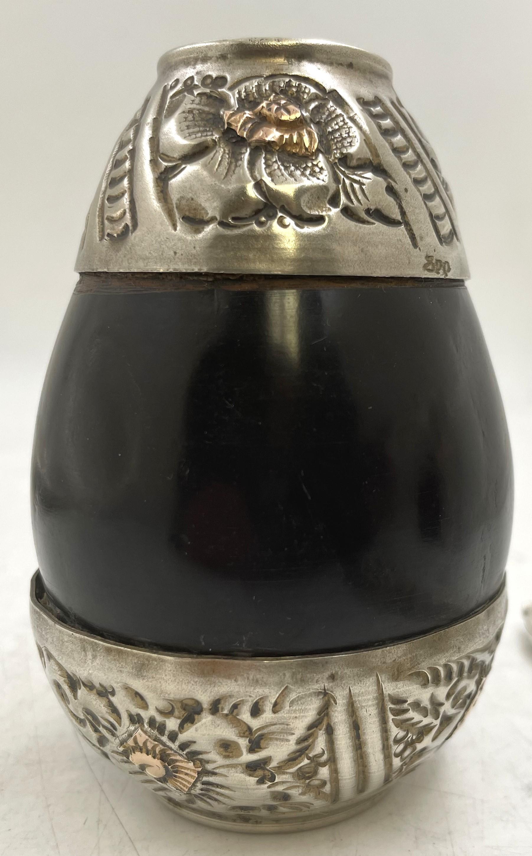 Argentinian 0.800 silver and wood mate cup with a straw (marked 18k at the top as shown) with floral and geometric motifs. The cup measures 4'' in height by 1 1/8'' in diameter at the top (overall depth is 2 3/4'' approximately) while the straw