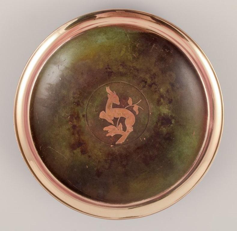 Argentor, Dänemark. Art-Deco-Bronzeschale mit Hirschmotiv.
Ungefähr 1940.
In ausgezeichnetem Zustand mit einer schönen grünen Patina.
Markiert.
Abmessungen: D 19,0 cm x H 3,0 cm.