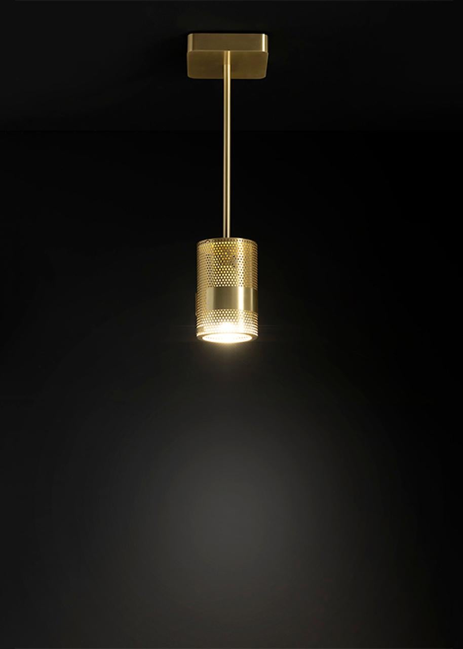 Suspension in slightly burnished brass. The handmade detail, almost suspended, screens and diffuses the light that comes from the light source inside the brass cylinder. Customizable drop.