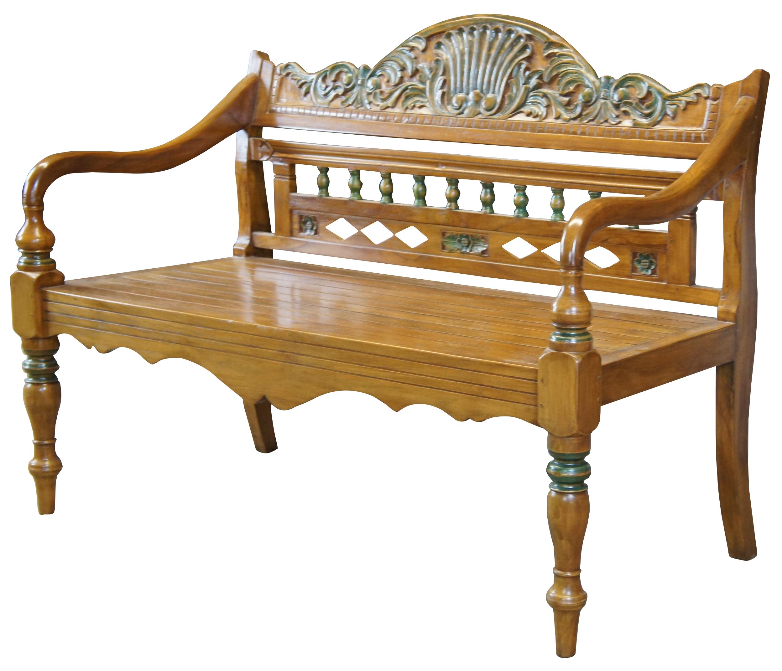 Vintage Arhause Furniture entry seat or hall bench. Made of teak, featuring carved scallop and leaf designs along the crest, rounded turnings and diamond-shaped piercings to the back, a slatted seat, curved armrests, and lathe-turned legs. Made in